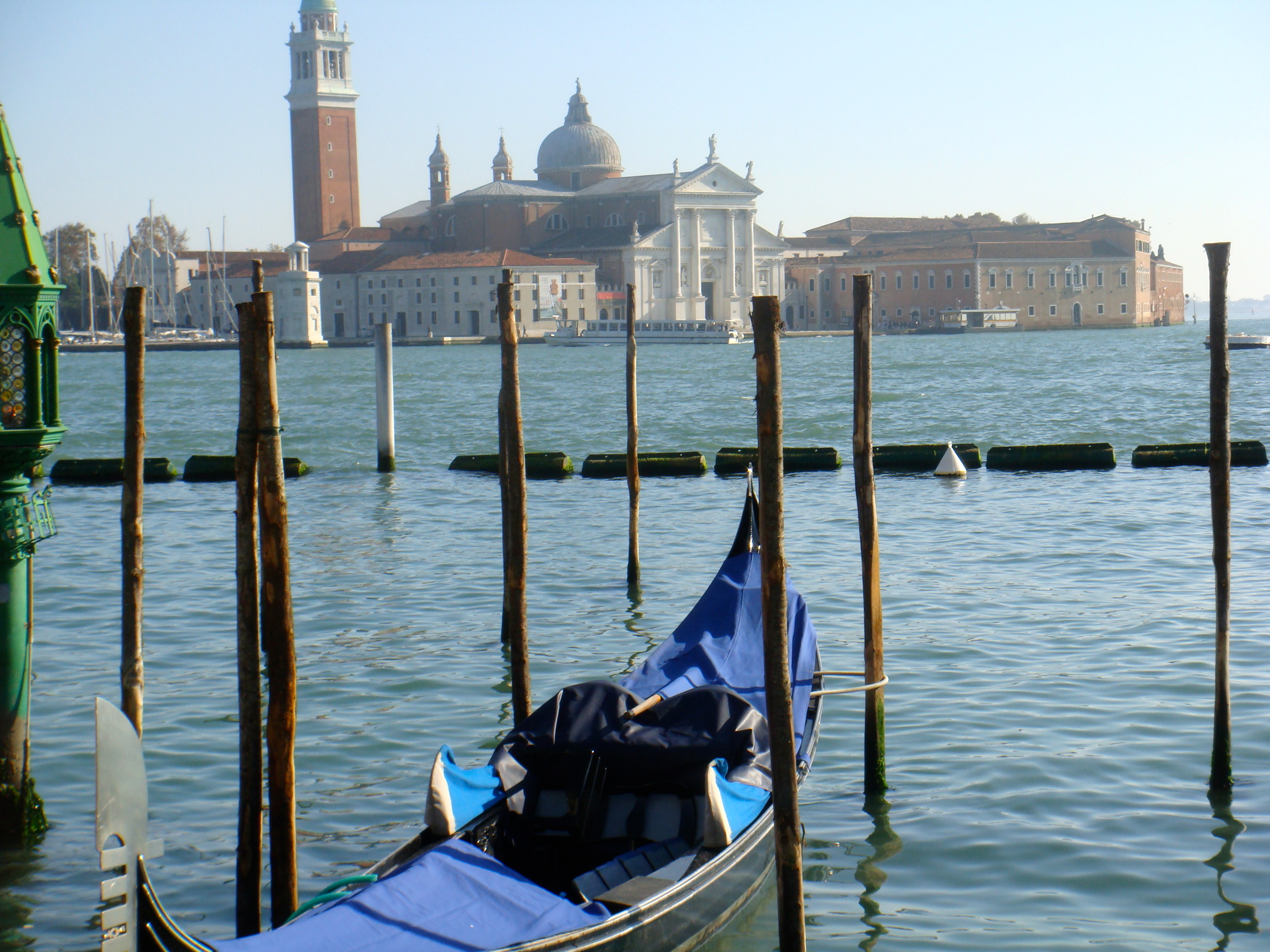 View of a gondola in Venice, Italy and a tower and domed cathedral visible across the water