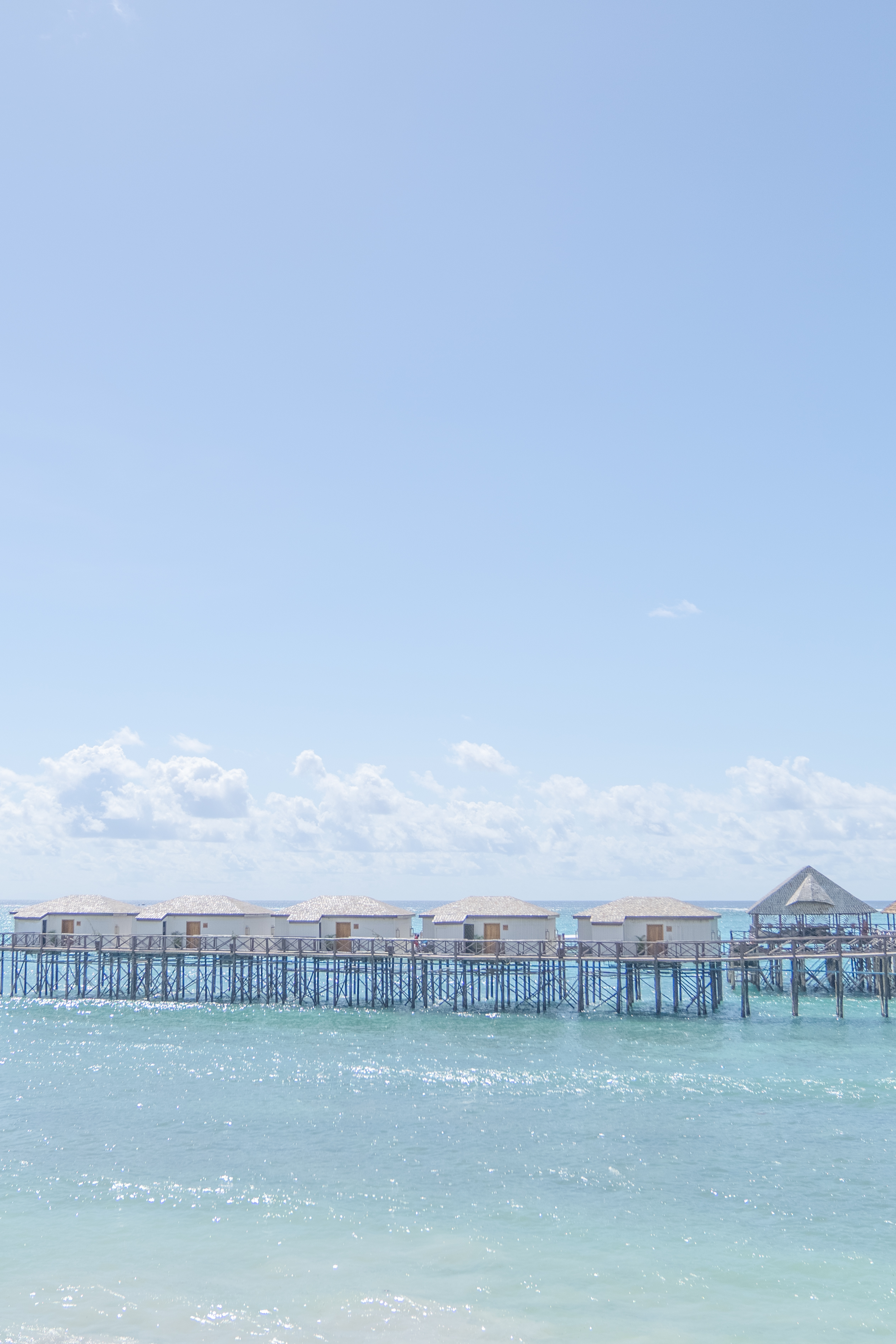 Pier buildings and structure stand proudly in the waves on a sunny day.
