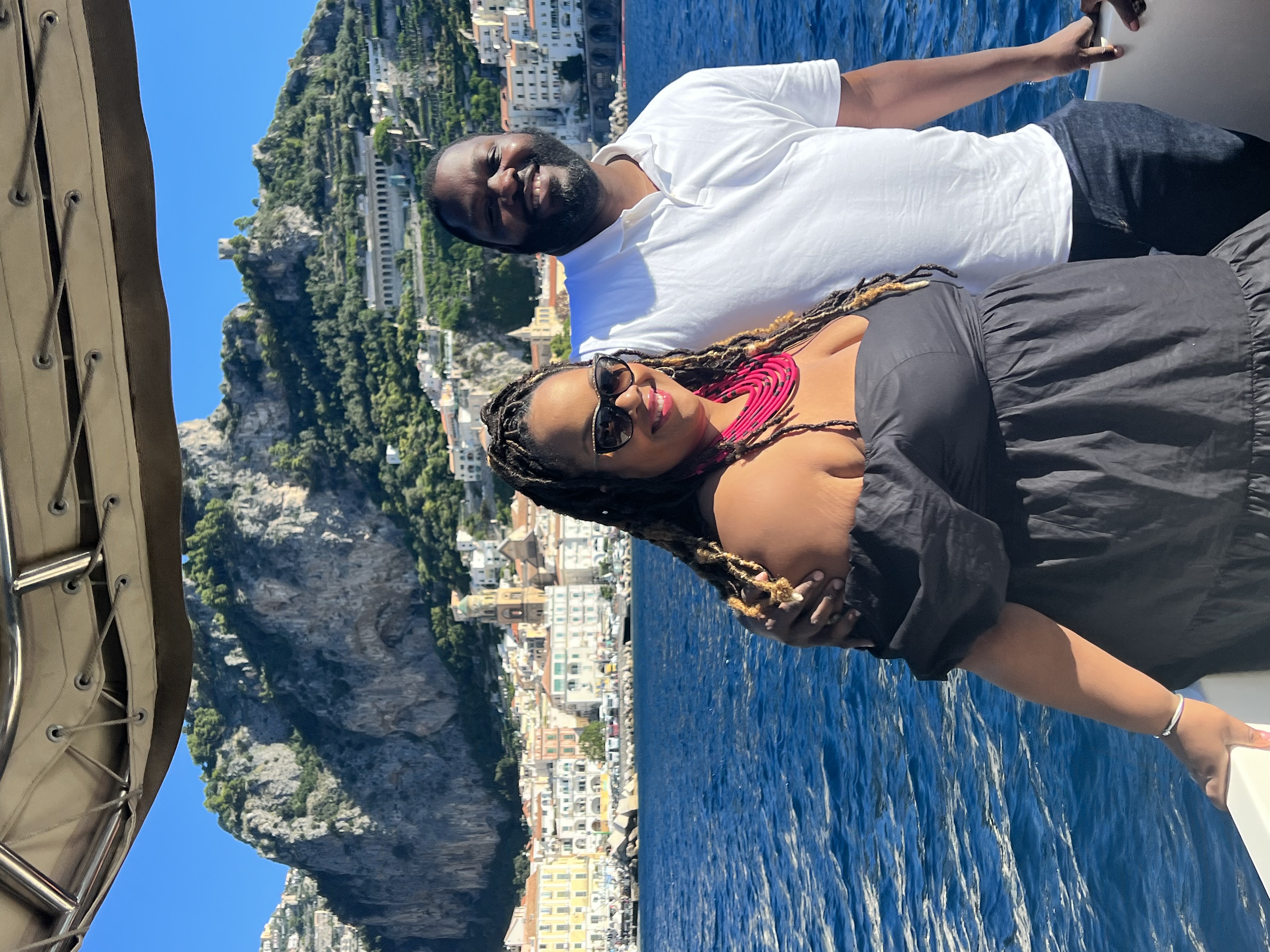 A couple posing for an photo on a boat during the day.