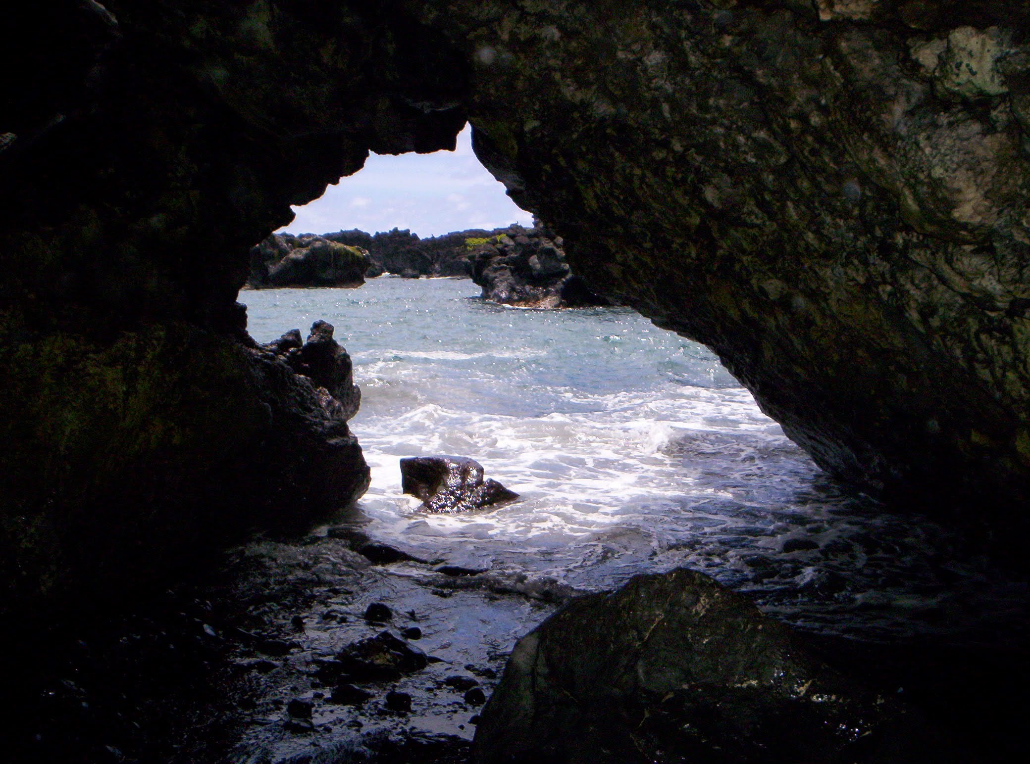 View of the ocean seen through an opening in a rock formation