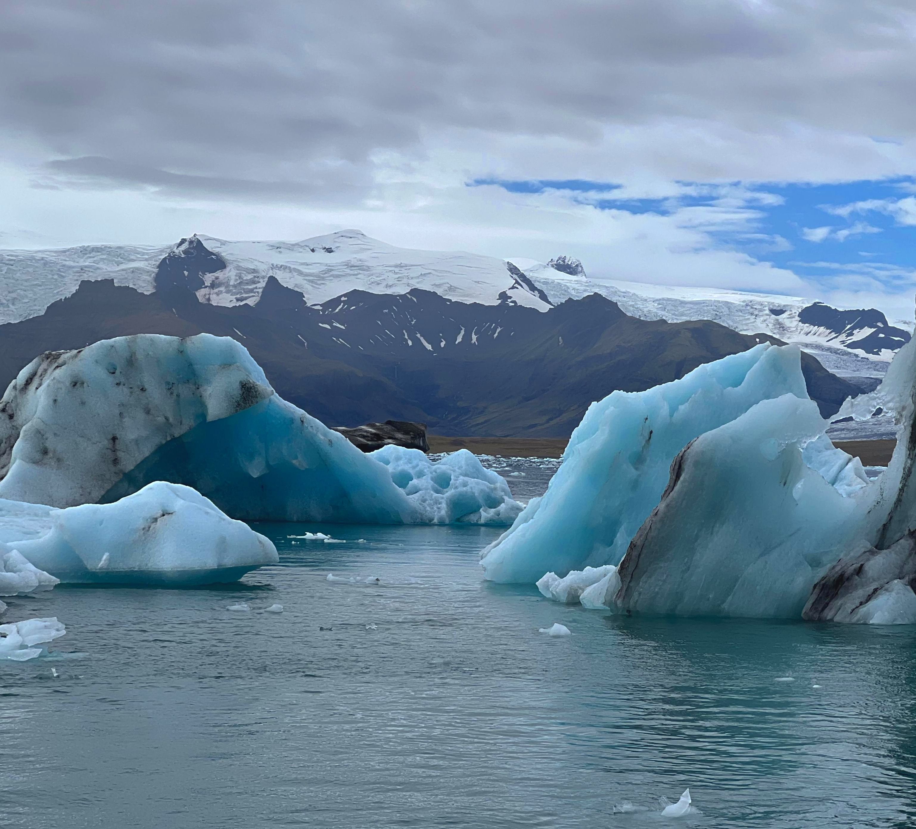 Beautiful view of blue glaciers and distant mountains under cloudy skies