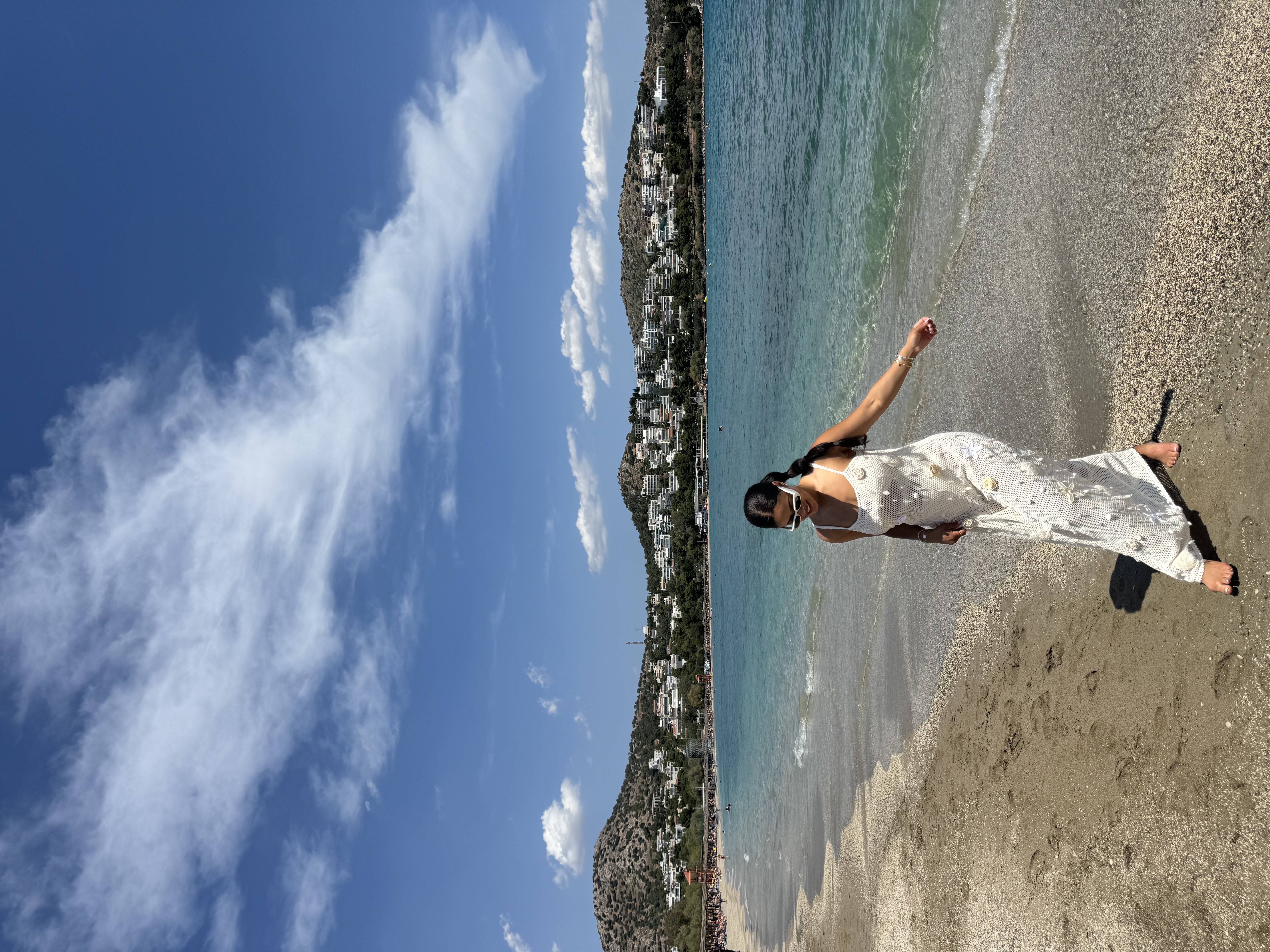 Advisor in a white dress on the beach under sunny skies