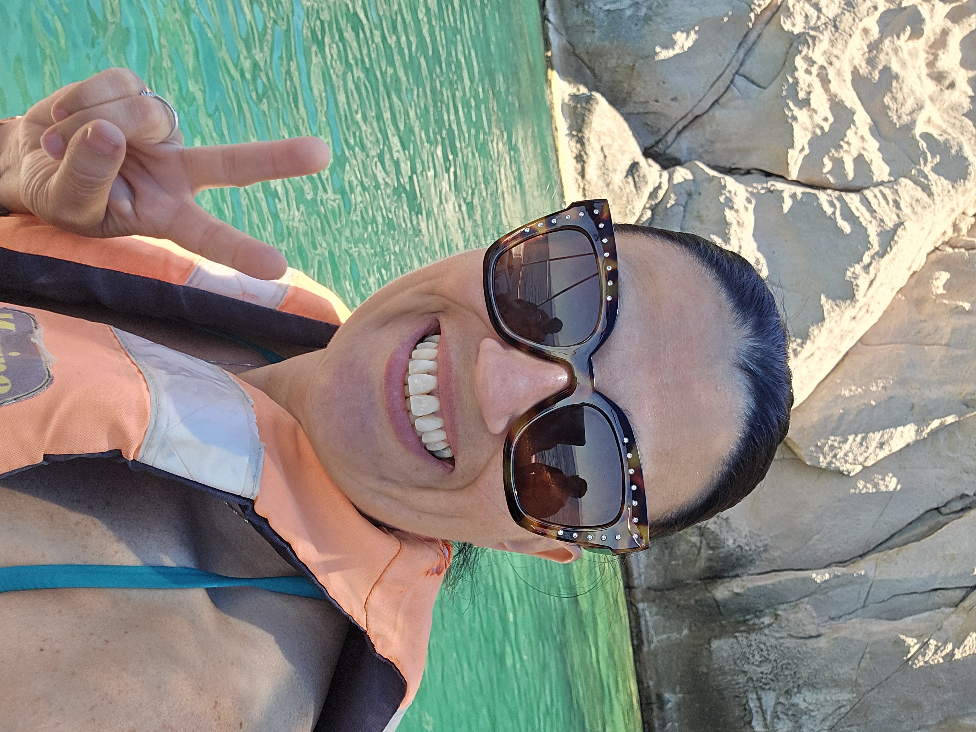 Advisor posing on a boat in front of waters.