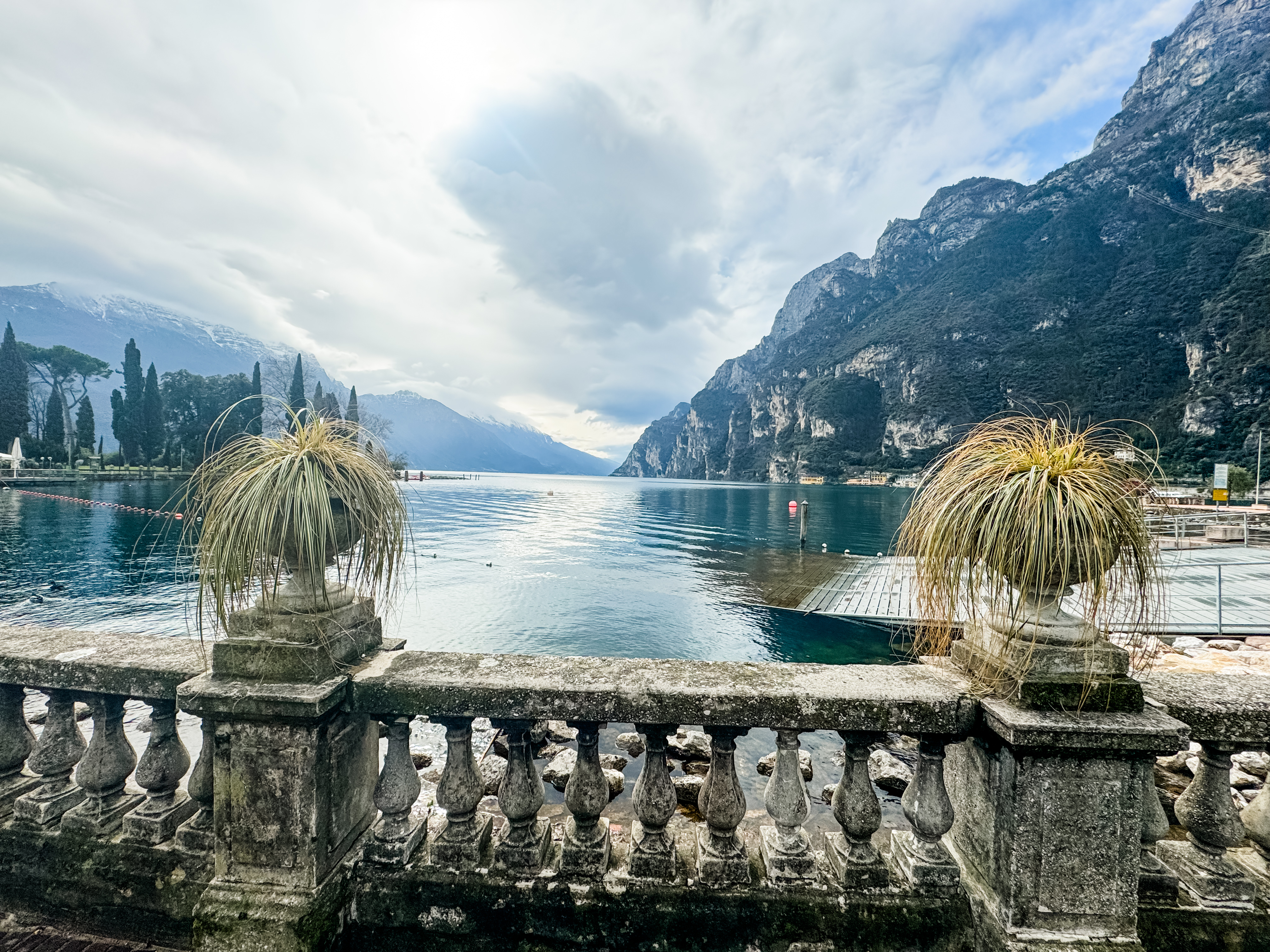 Beautiful view of a balcony overlooking a glassy lake surrounded by mountains