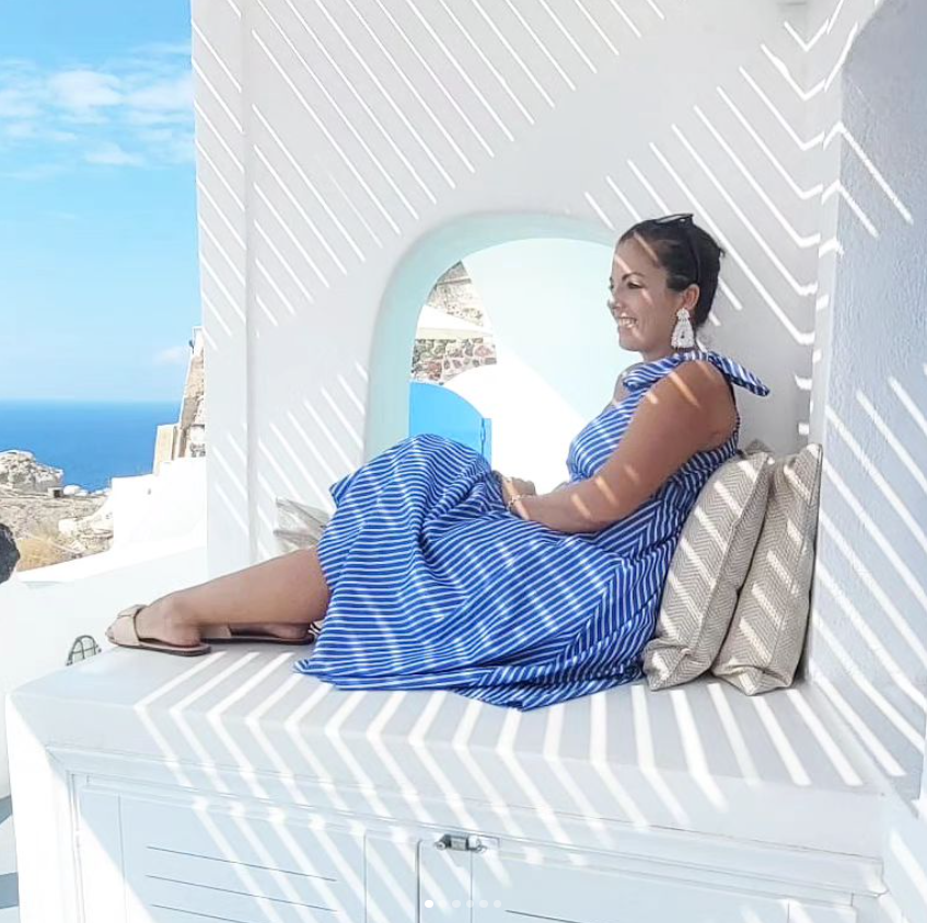 Sitting on a white wall in Santorini.