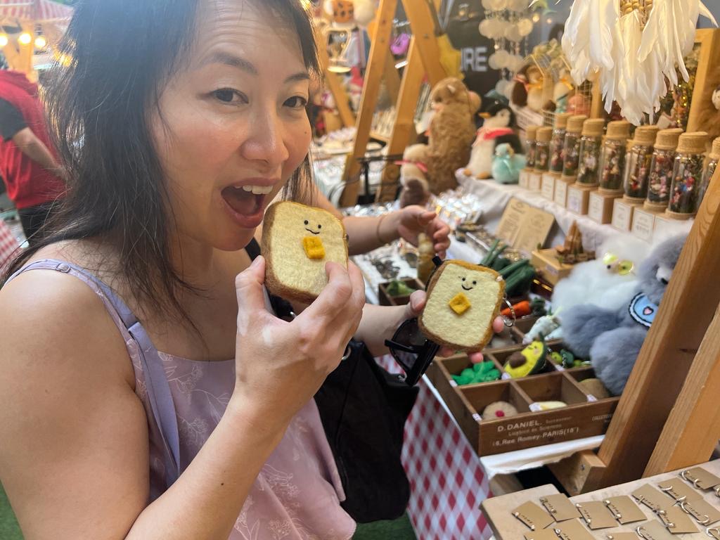 Advisor holding a frosted cookie to her mouth in a market