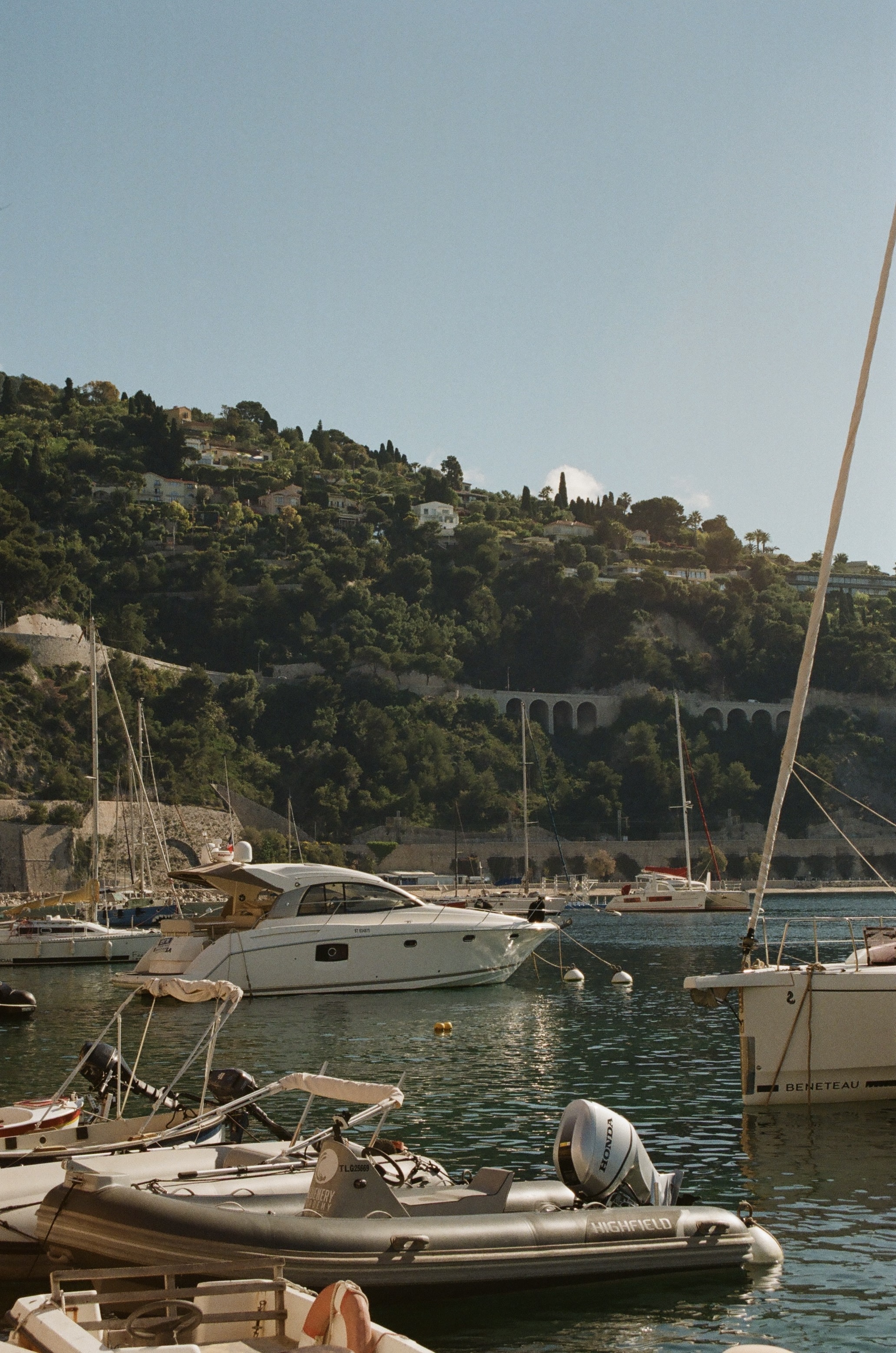 Small boats docked in a small port under clear skies