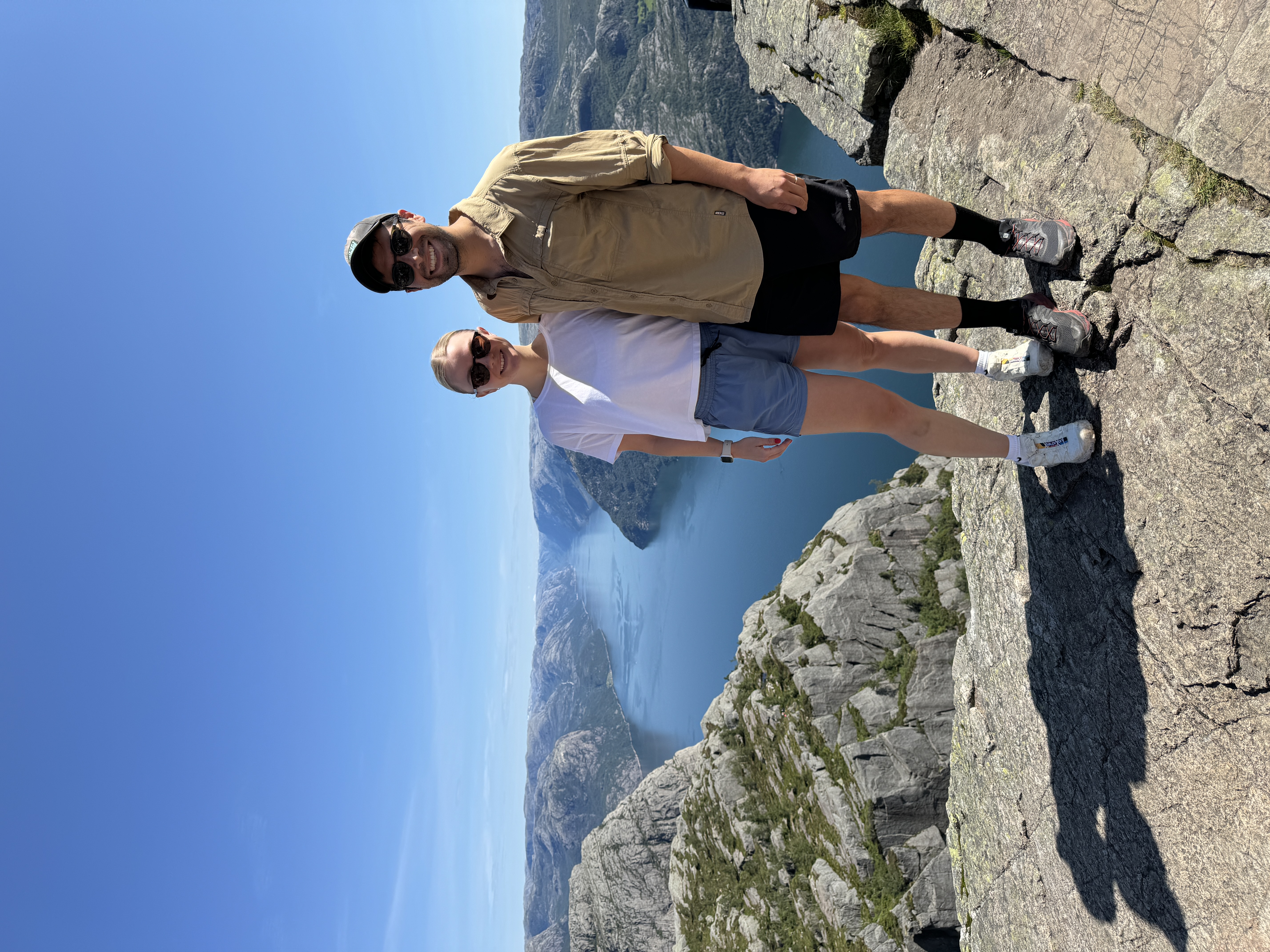 Advisor and partner side by side at a viewpoint overlooking a beautiful river canyon under clear skies