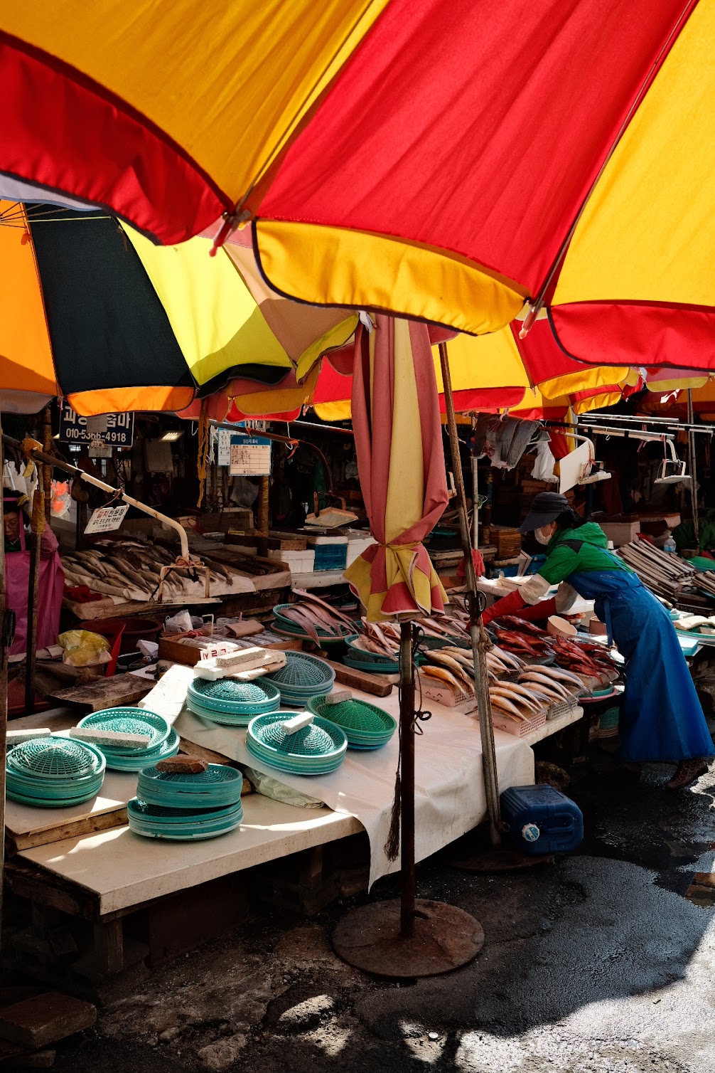 View of a market table under red and yellow umbrellas