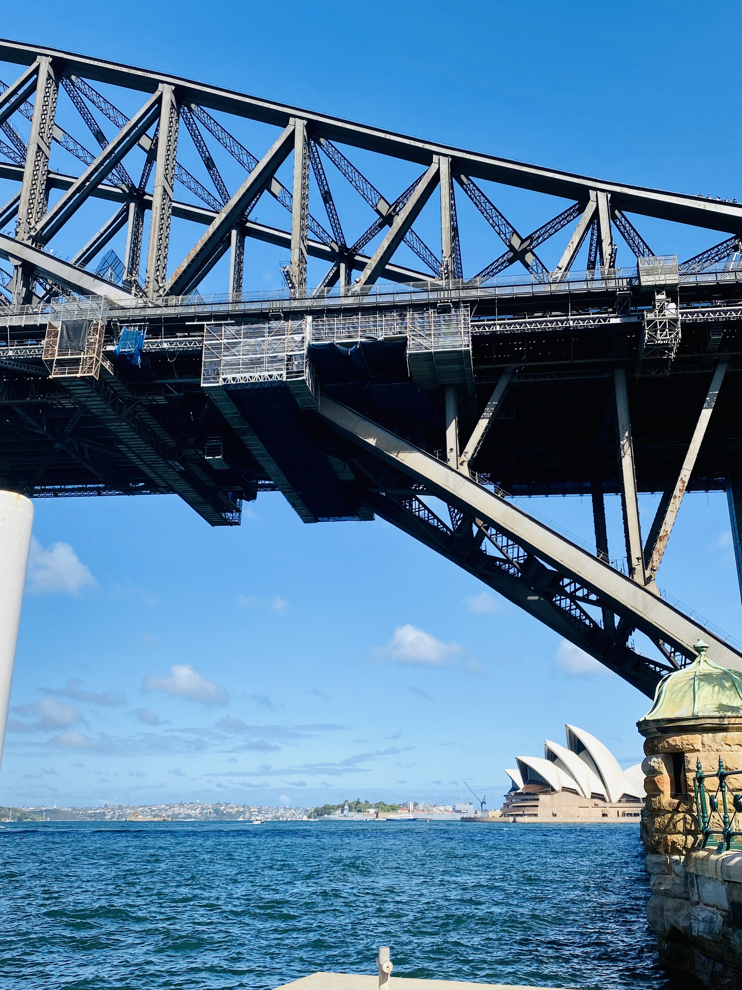 A view of a bridge with the ocean in the distance on a sunny day.