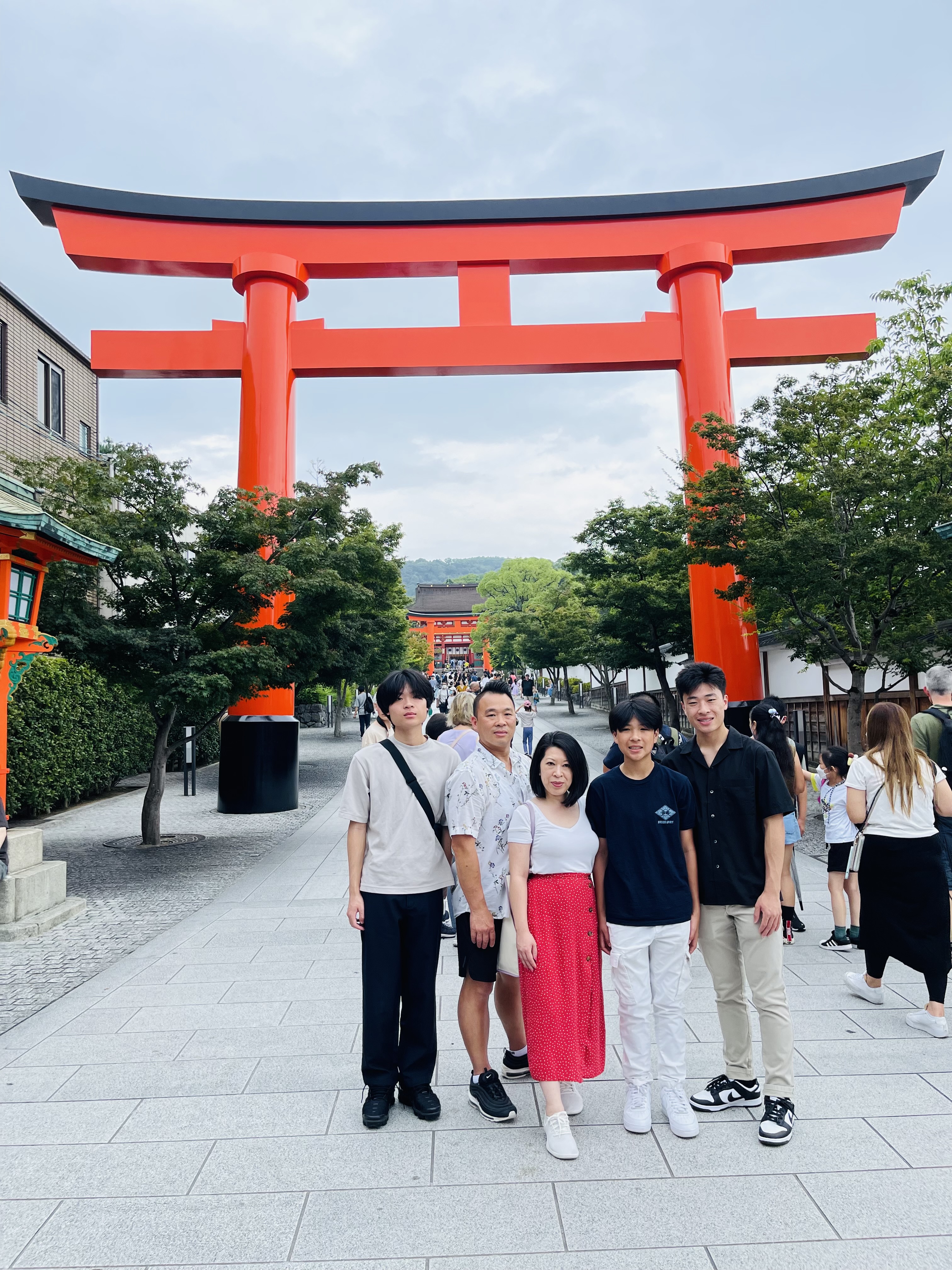 Advisor and family posing in front of a shrine in Japan on a cloudy day