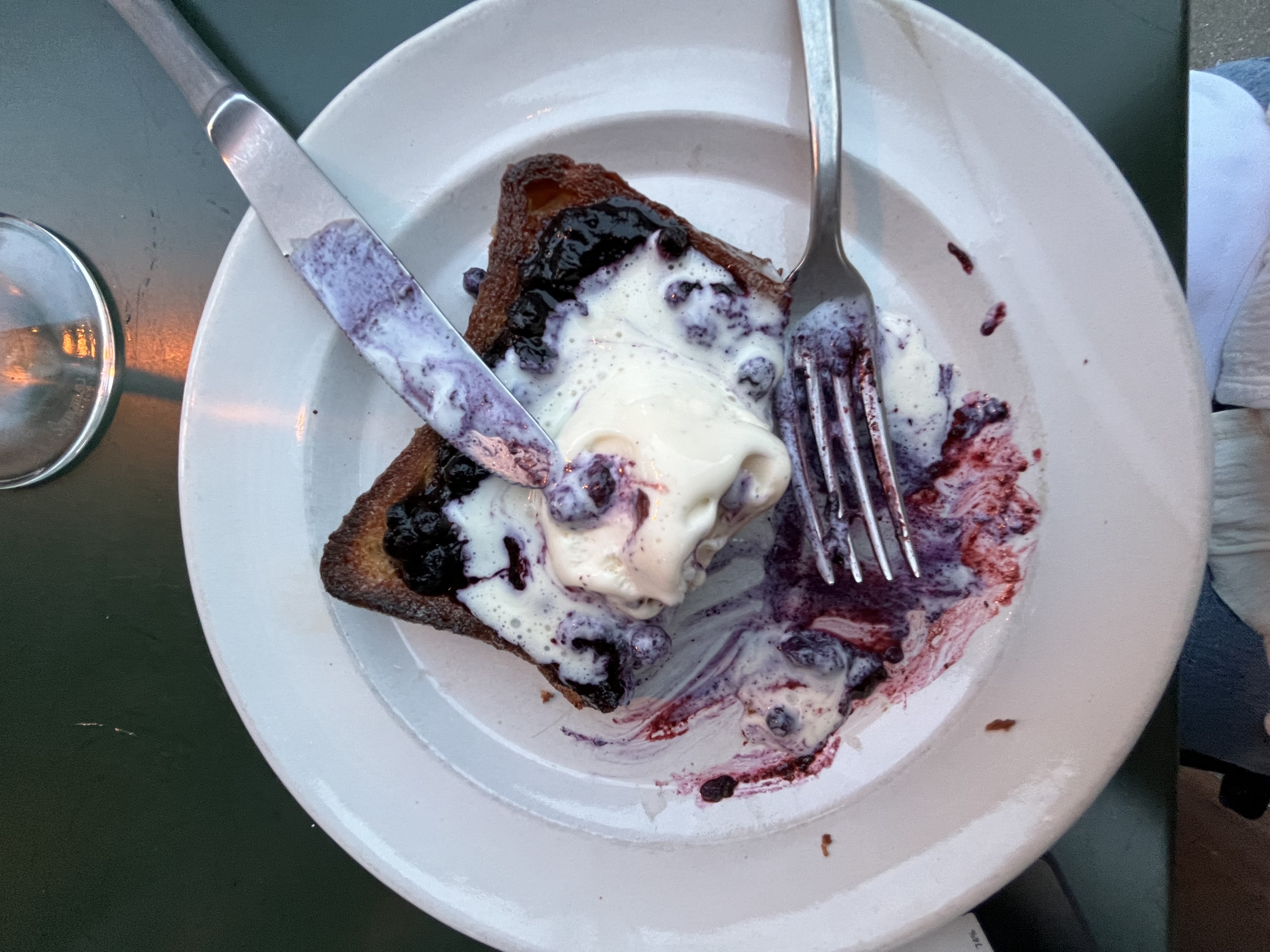 Toast with whipped cream and jam on a white plate.