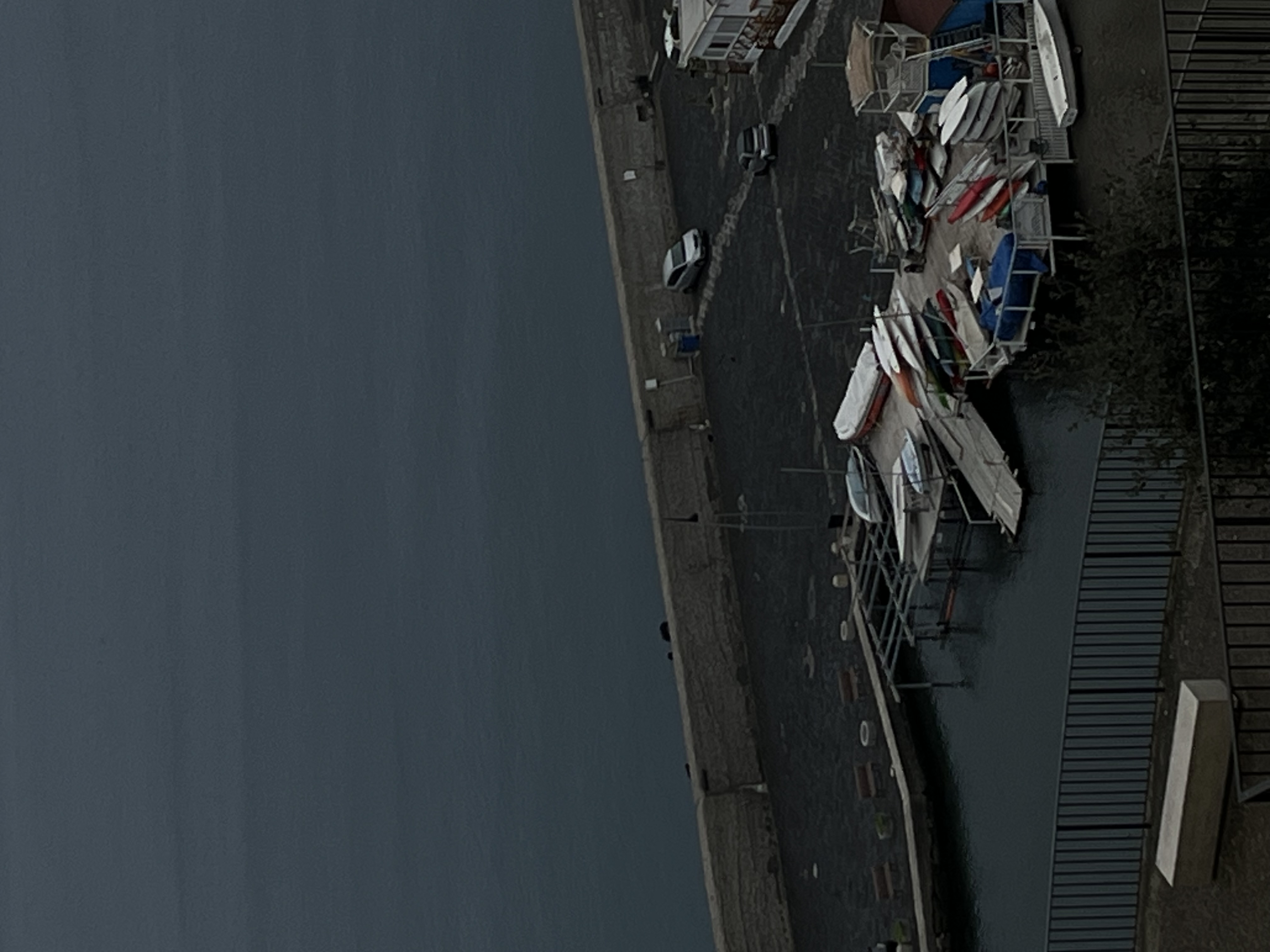 Sea kayaks on a concrete pier.