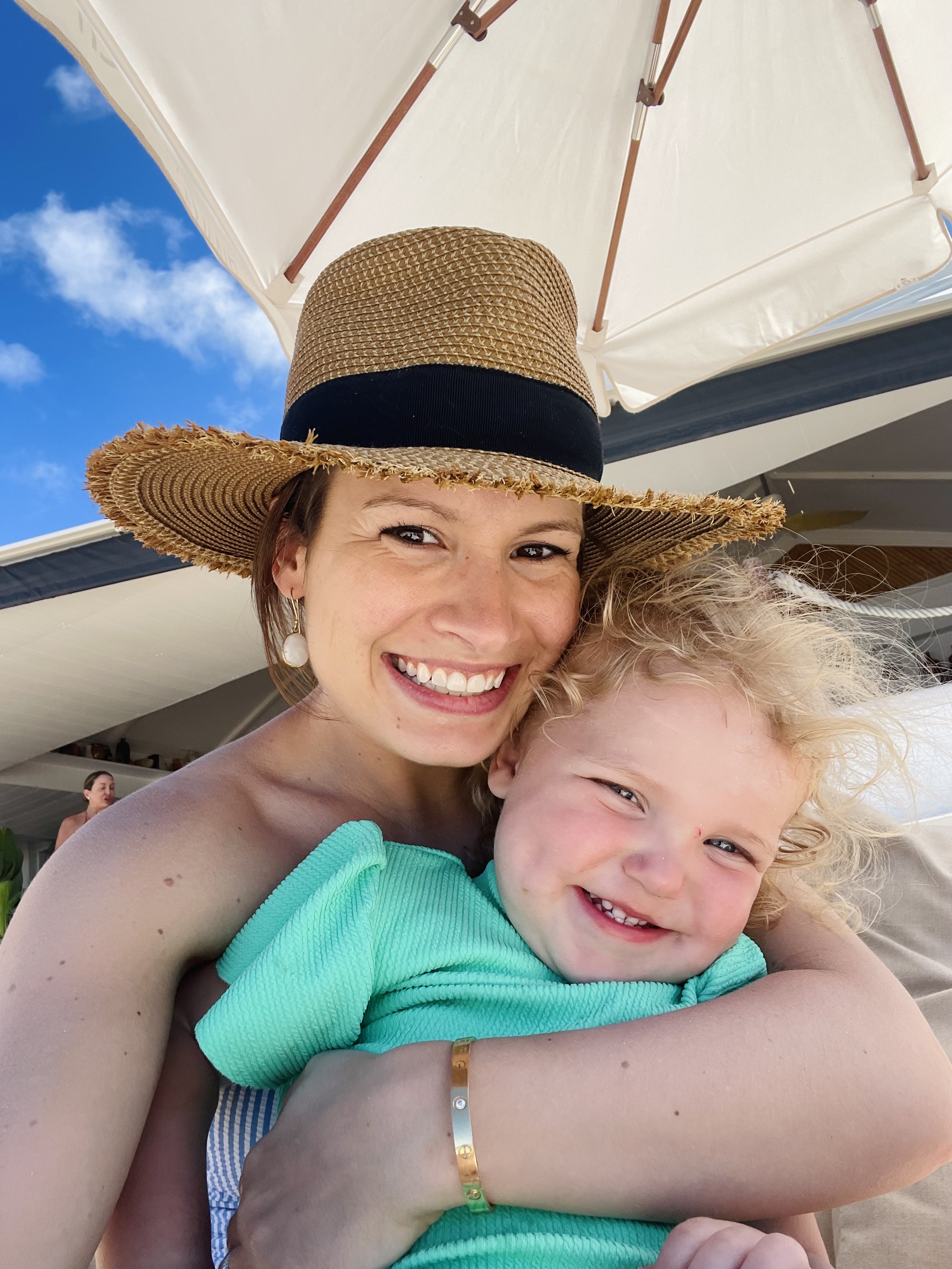 Advisor posing for an image with her child on a boat on a sunny day.