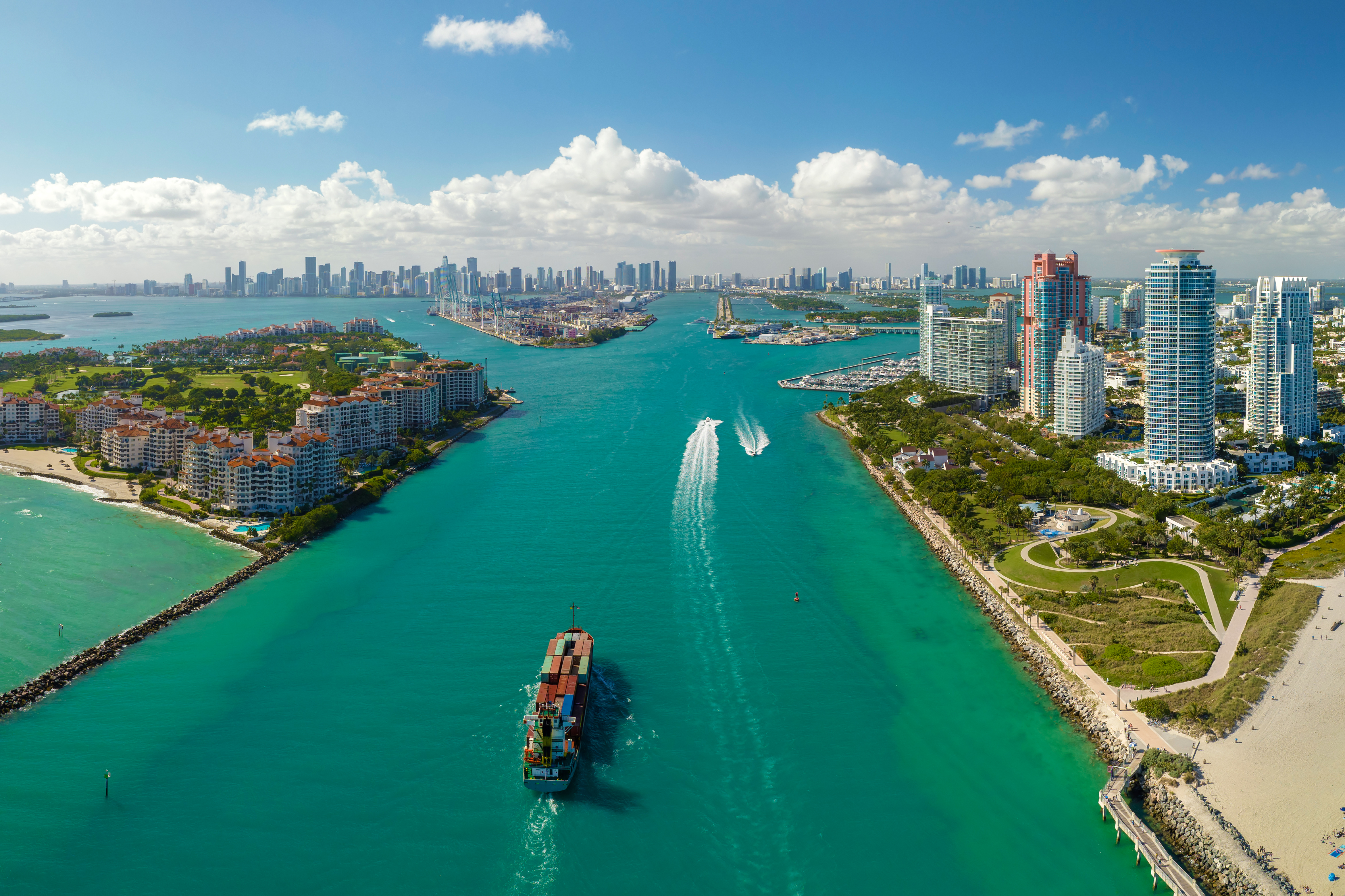 Aerial view of a boat sailing through a waterway on a sunny day.