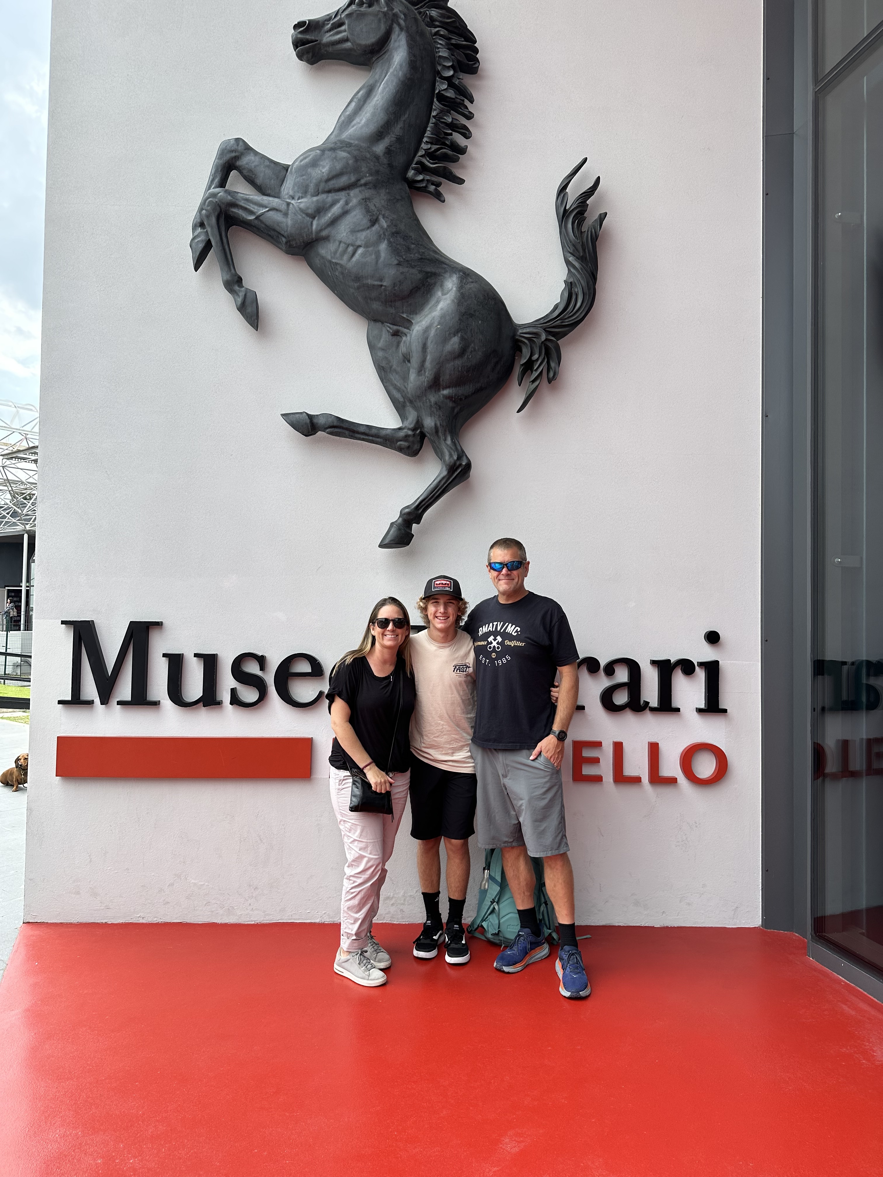 A family posing on the outside of the Ferrari Museum in Monza, Italy.