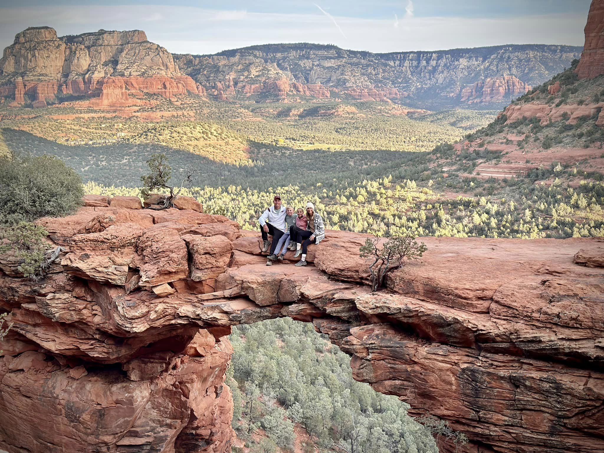 Advisor and family on a hike overlooking a beautiful green valley in Sedona, Arizona