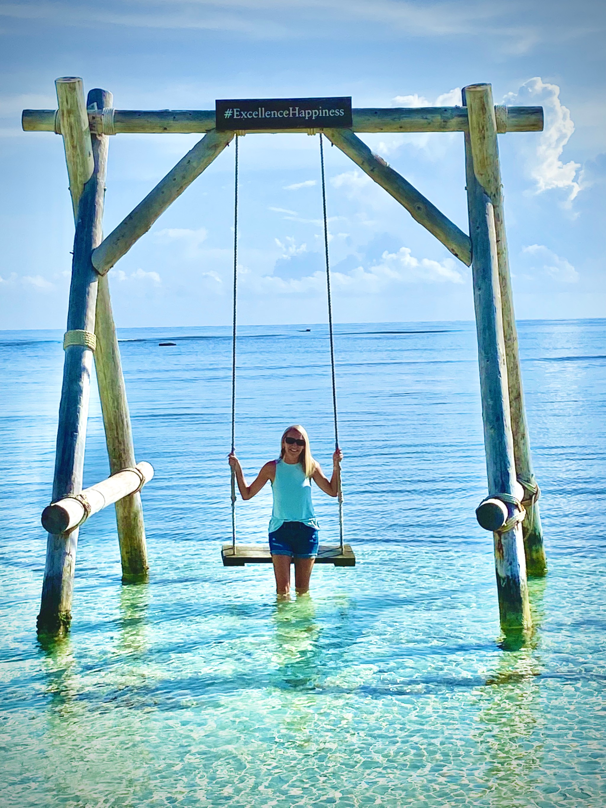 Advisor sitting on a wooden swing in shallow ocean water on a sunny day