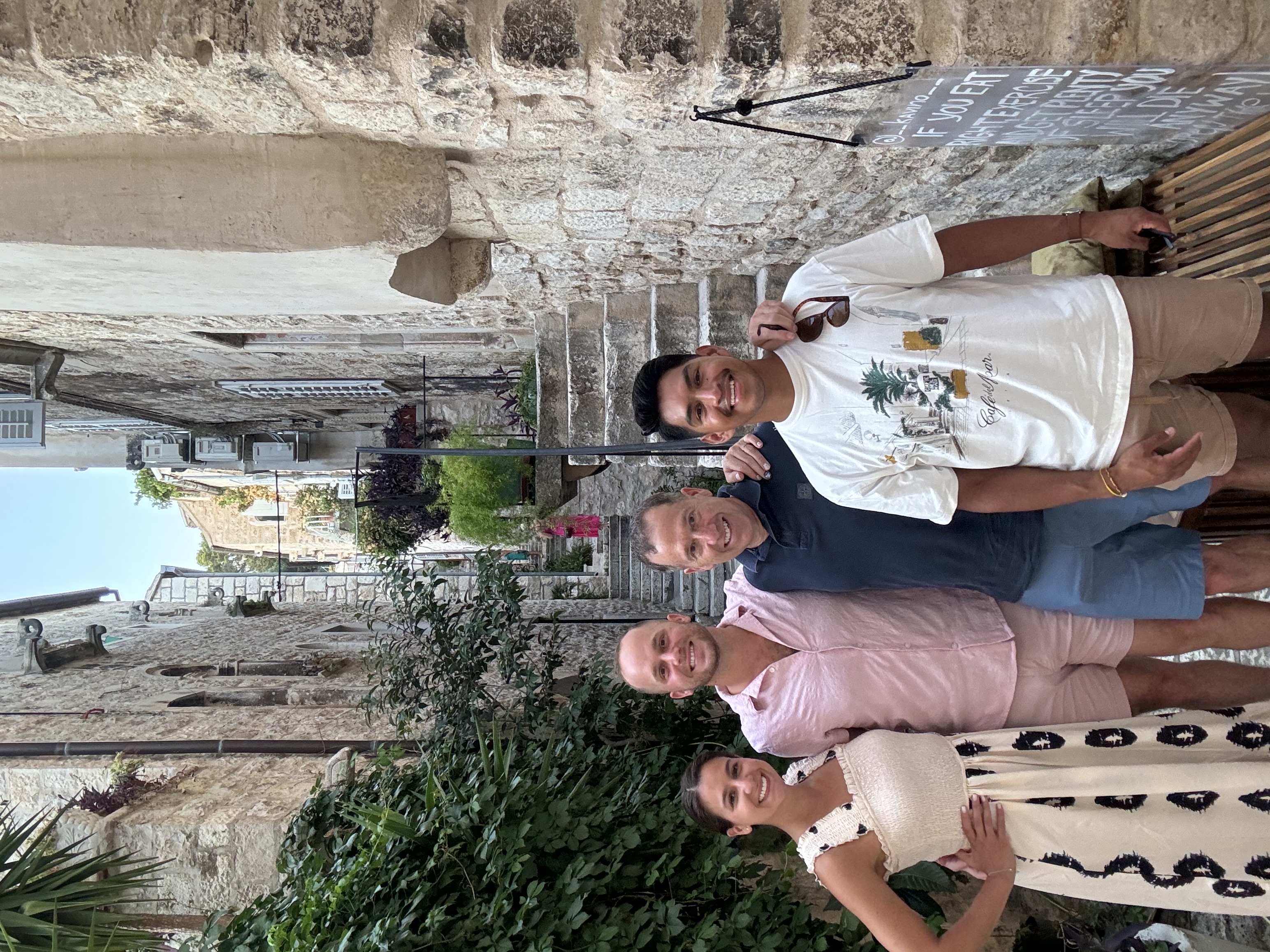 Jeffrey and friends posing in between houses outdoors.