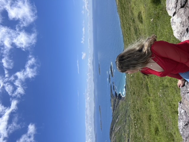 Advisor sitting on a ledge overlooking a beautiful coastline in Ireland