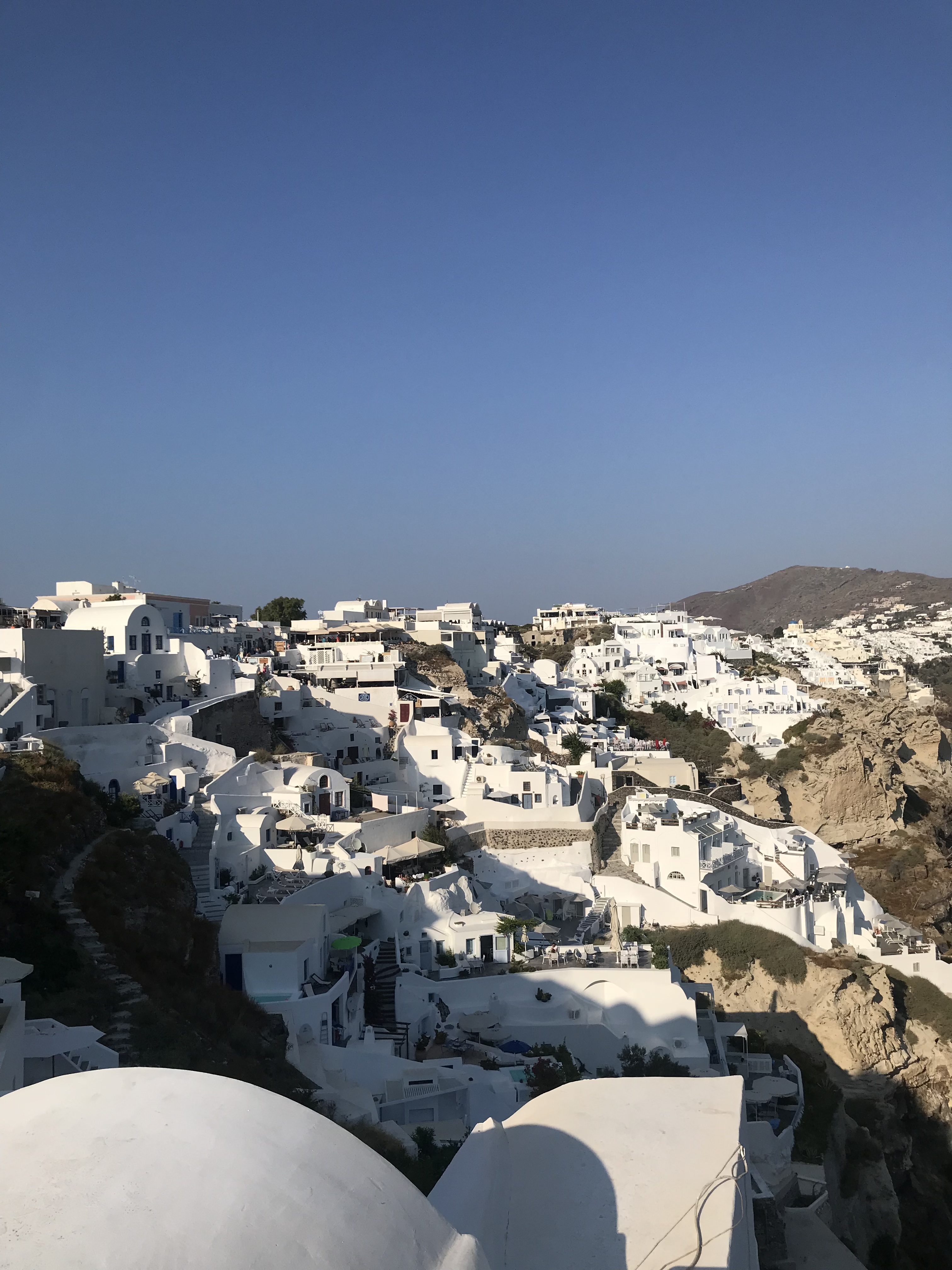 View of white buildings under a clear sky in Santorini