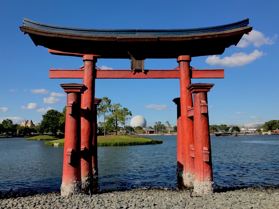 View of a Japanese Torii gate by a pond on a sunny day