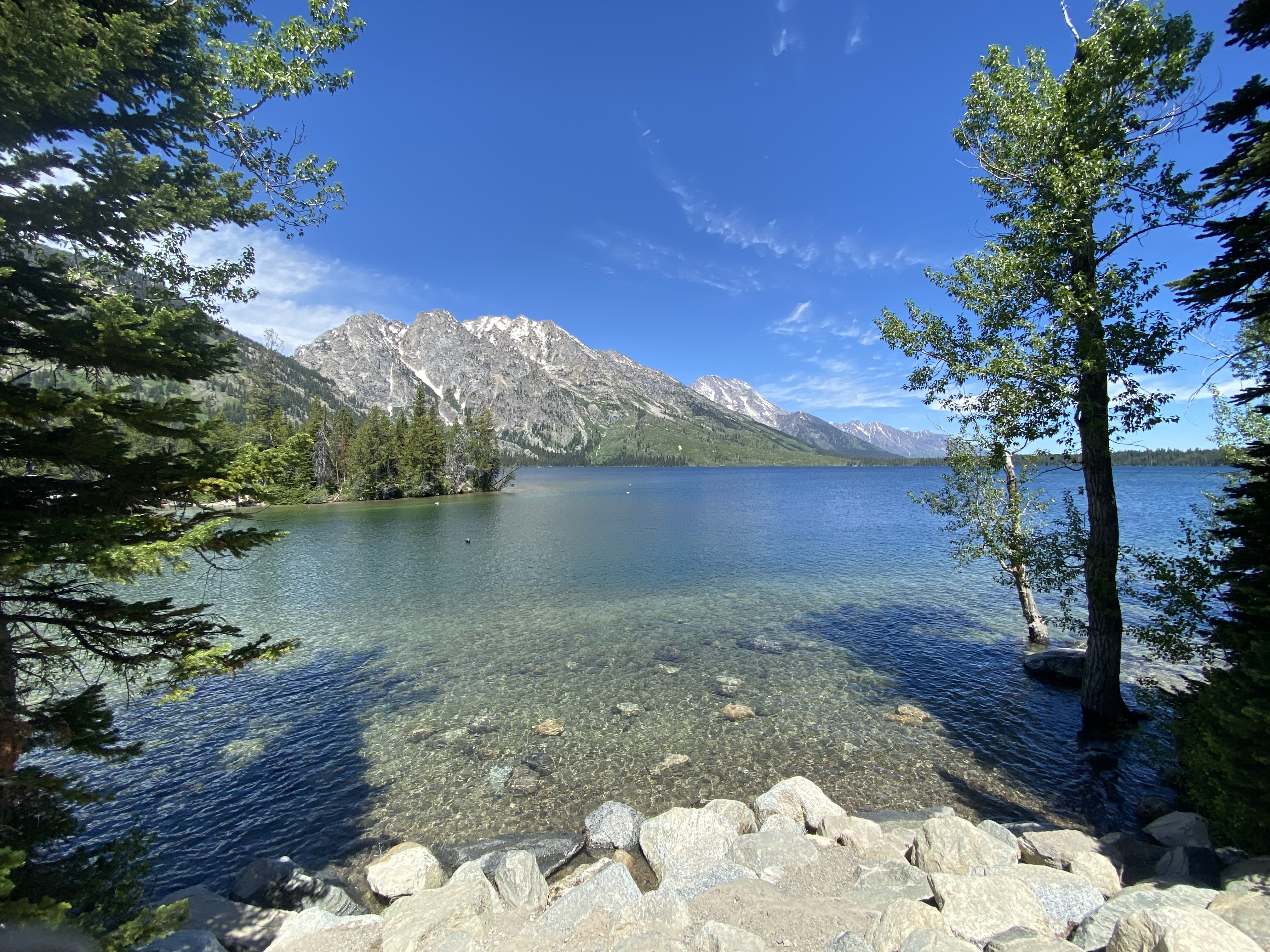 Clear water by mountains.