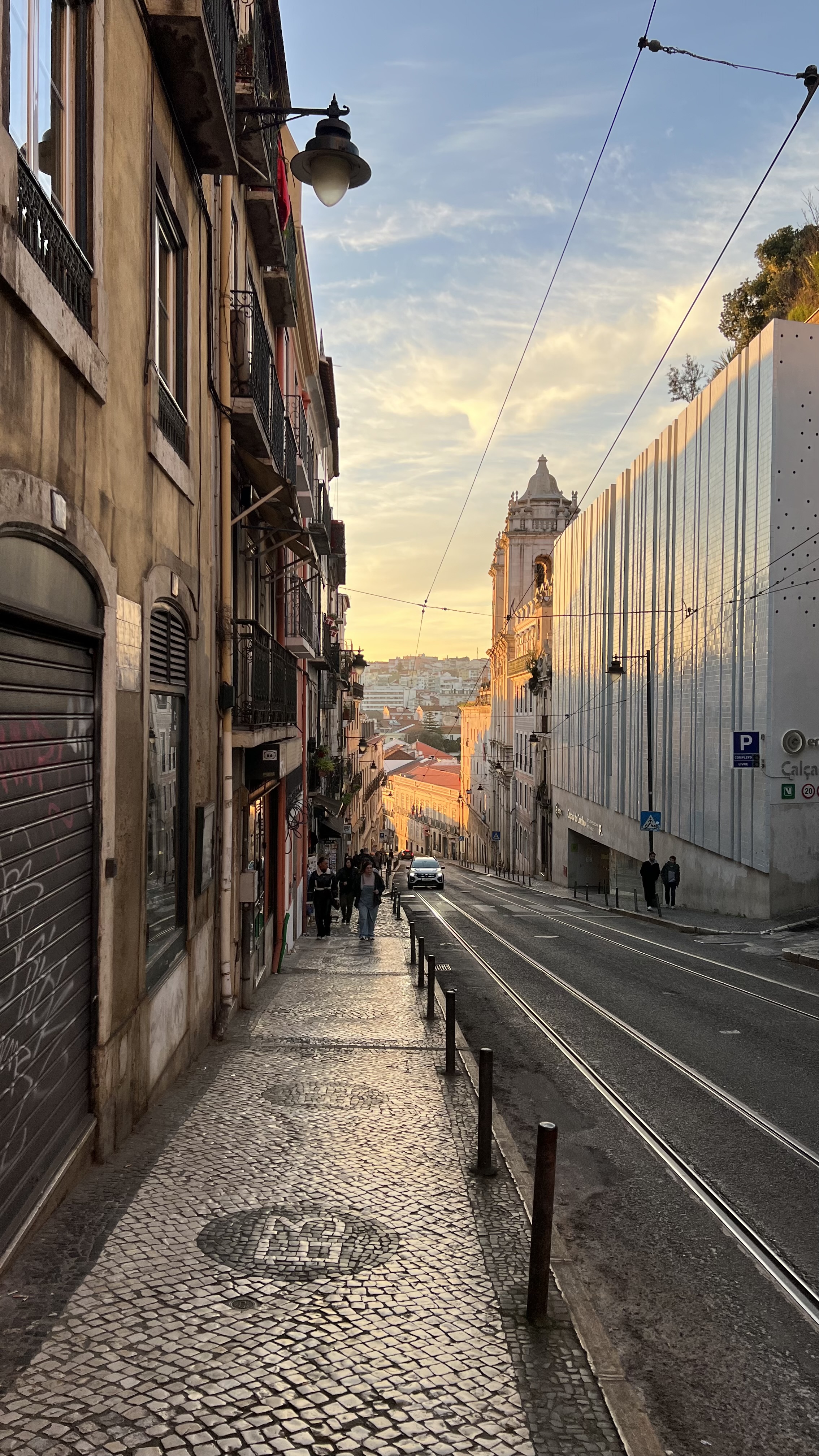 View of a cobblestone sidewalk and empty city street at sunrise