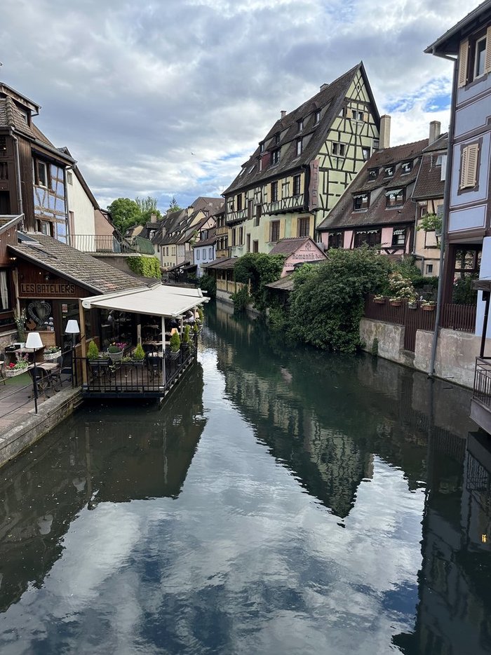 A picturesque canal in Colmar, France, surrounded by charming buildings and lush greenery.