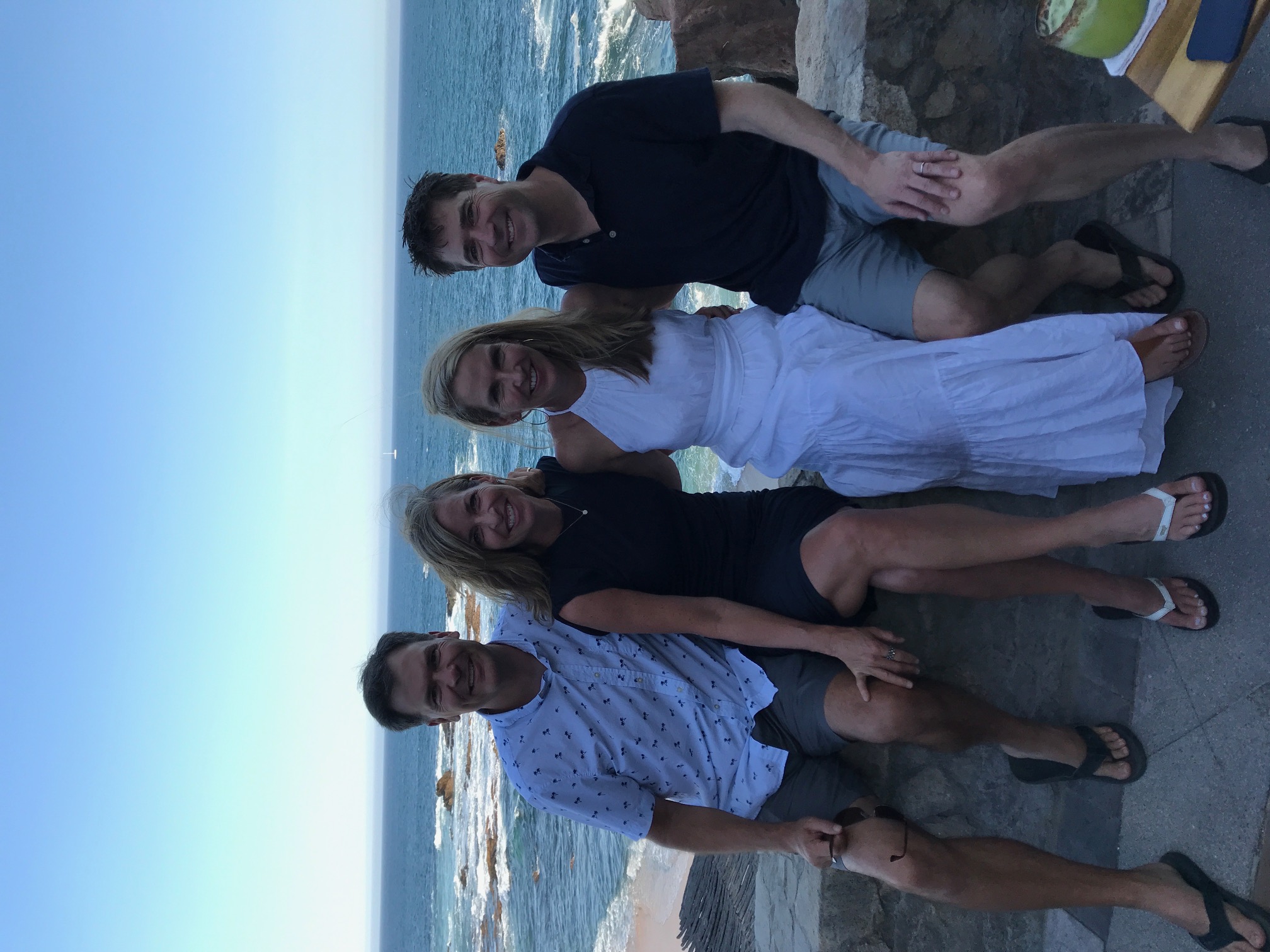 Advisor and family sitting side by side on a sunny day at the beach