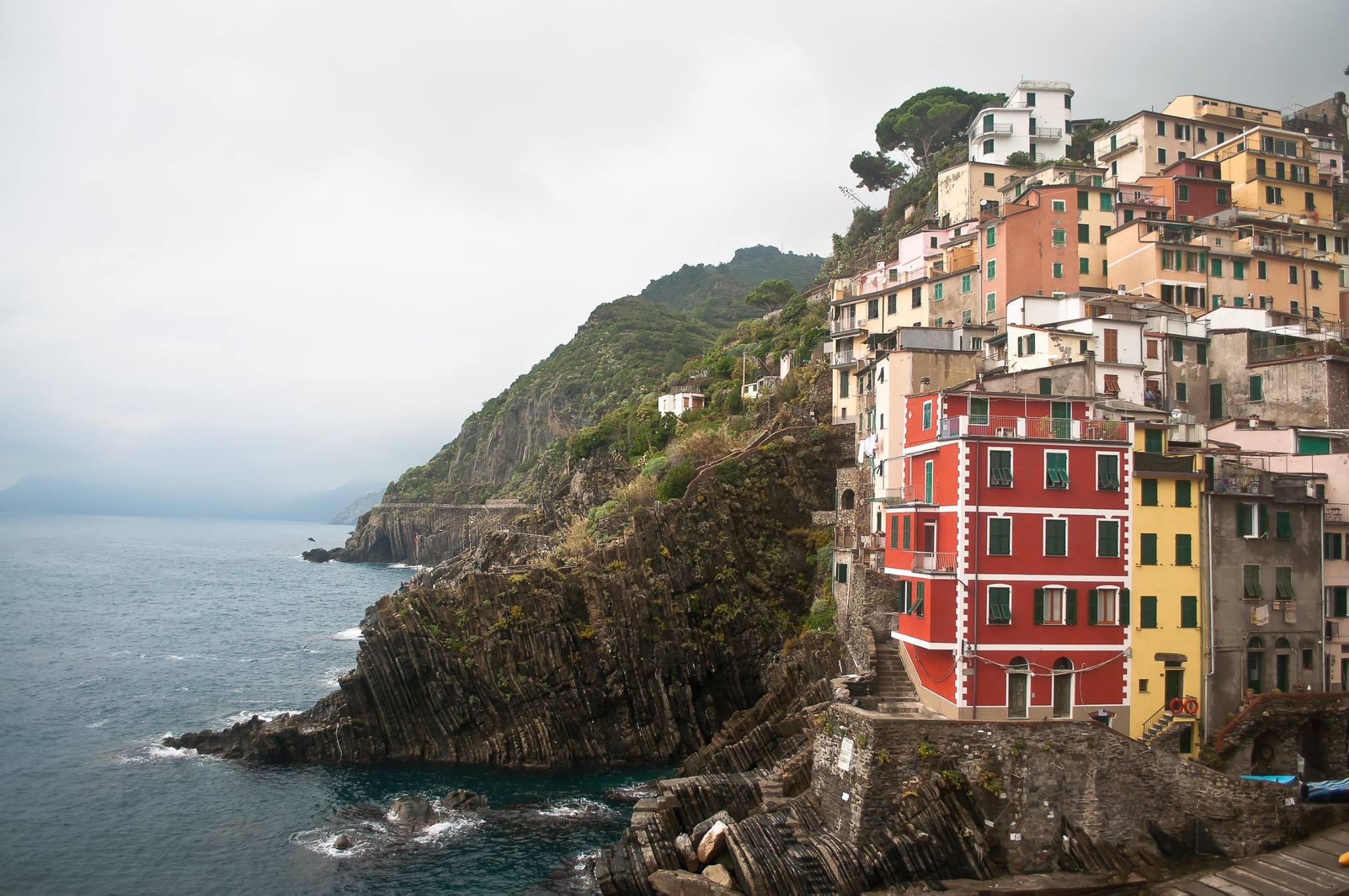 View of a colorful coastal town on a cliffside on a cloudy day