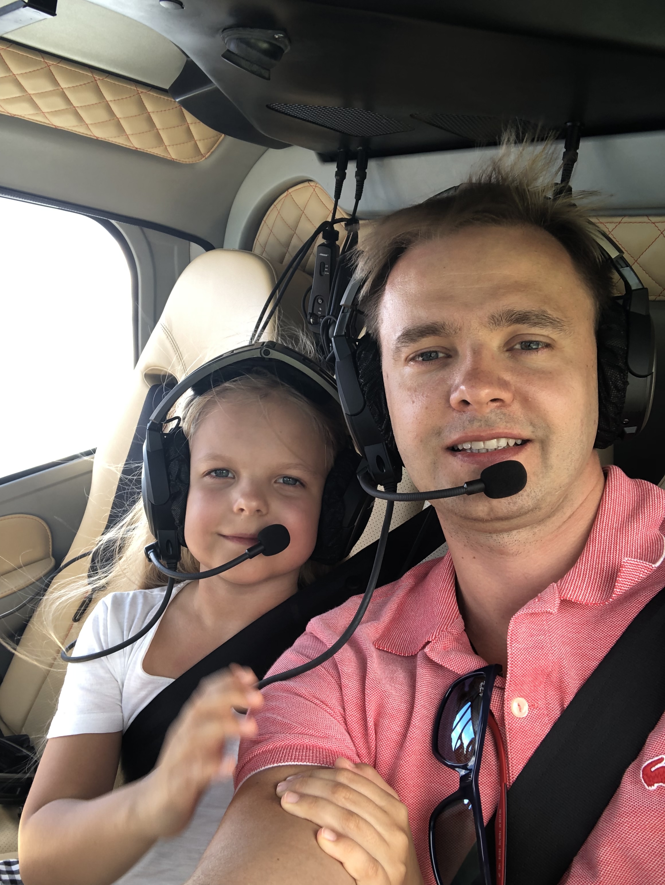 A man and child posing for a selfie inside of an airplane.