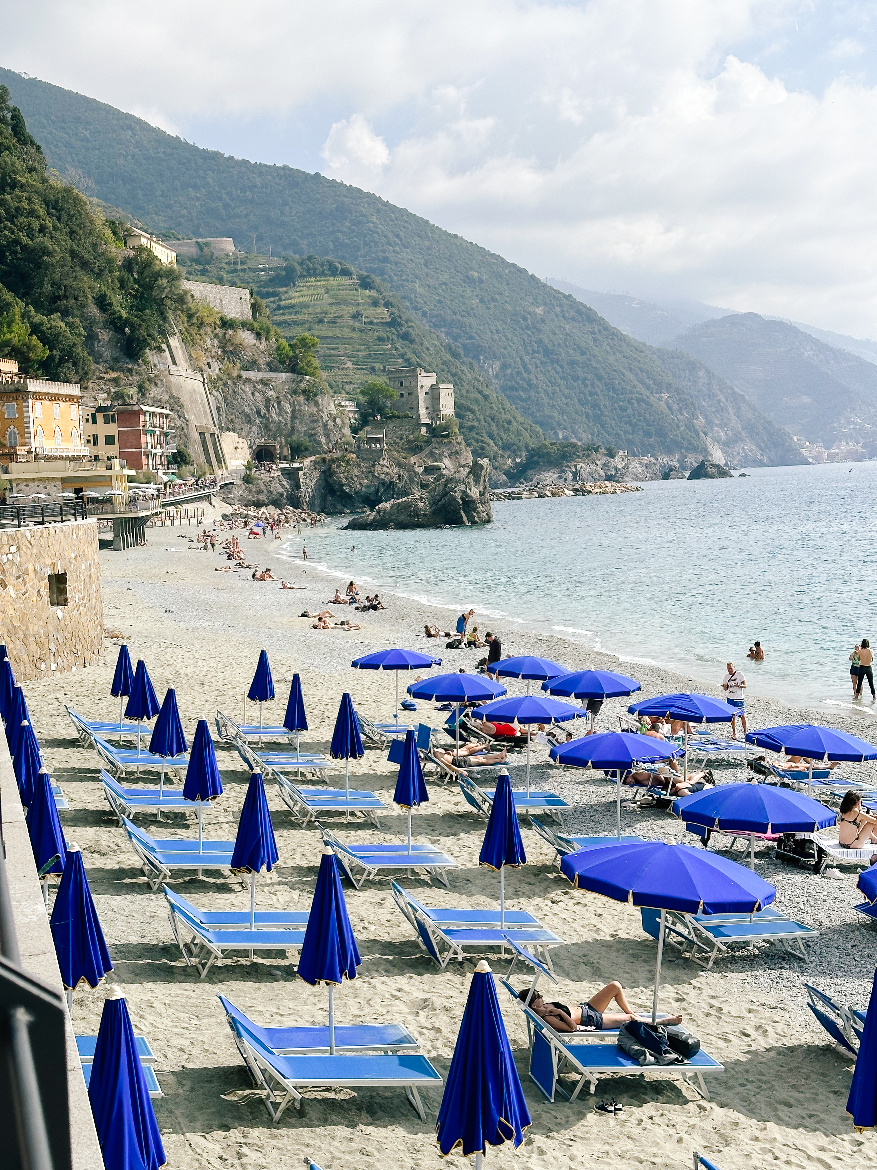 View of blue lounge chairs and umbrellas on a beach during the day