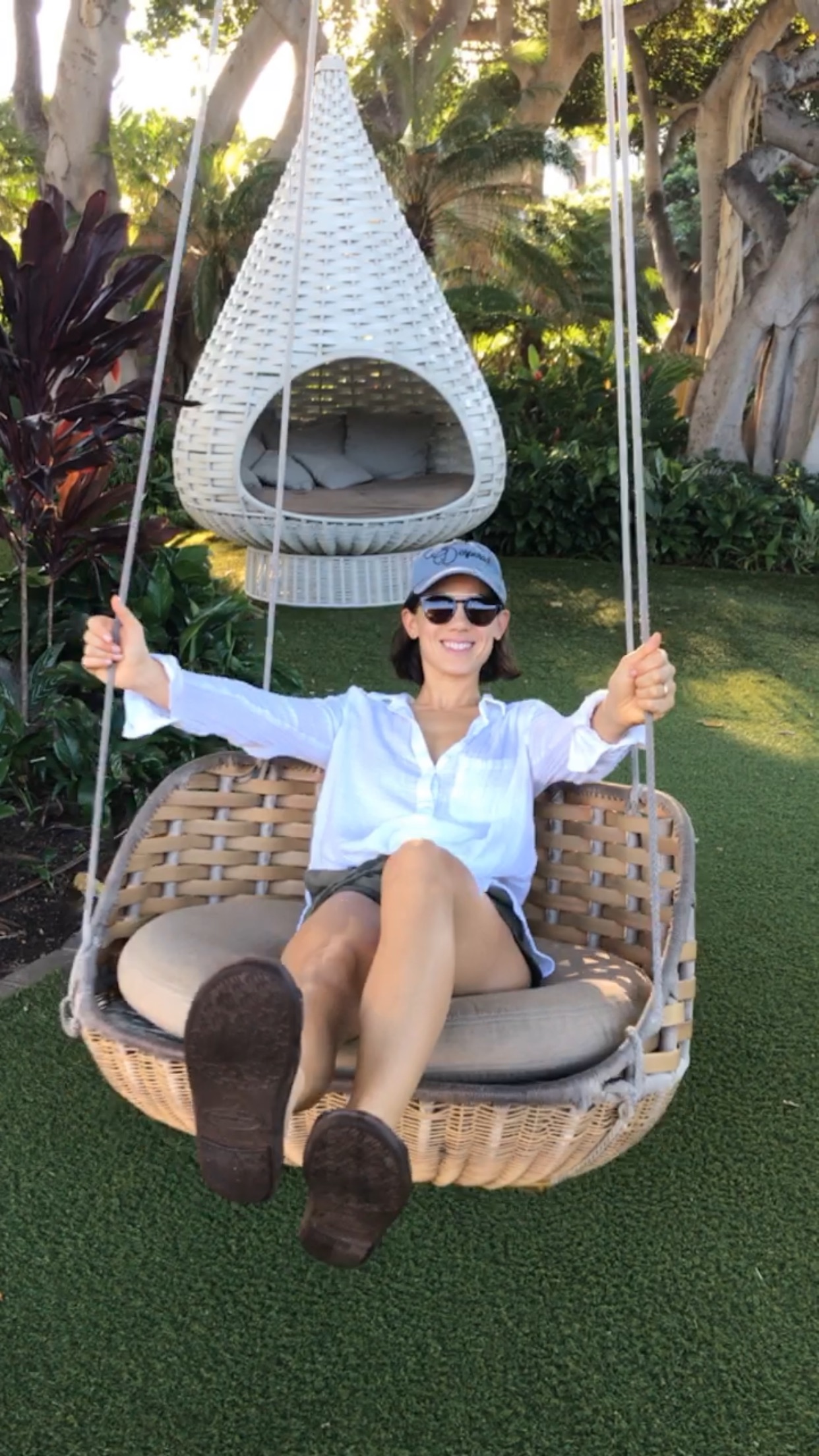 Advisor sitting in a swinging chair outdoors in a grassy area