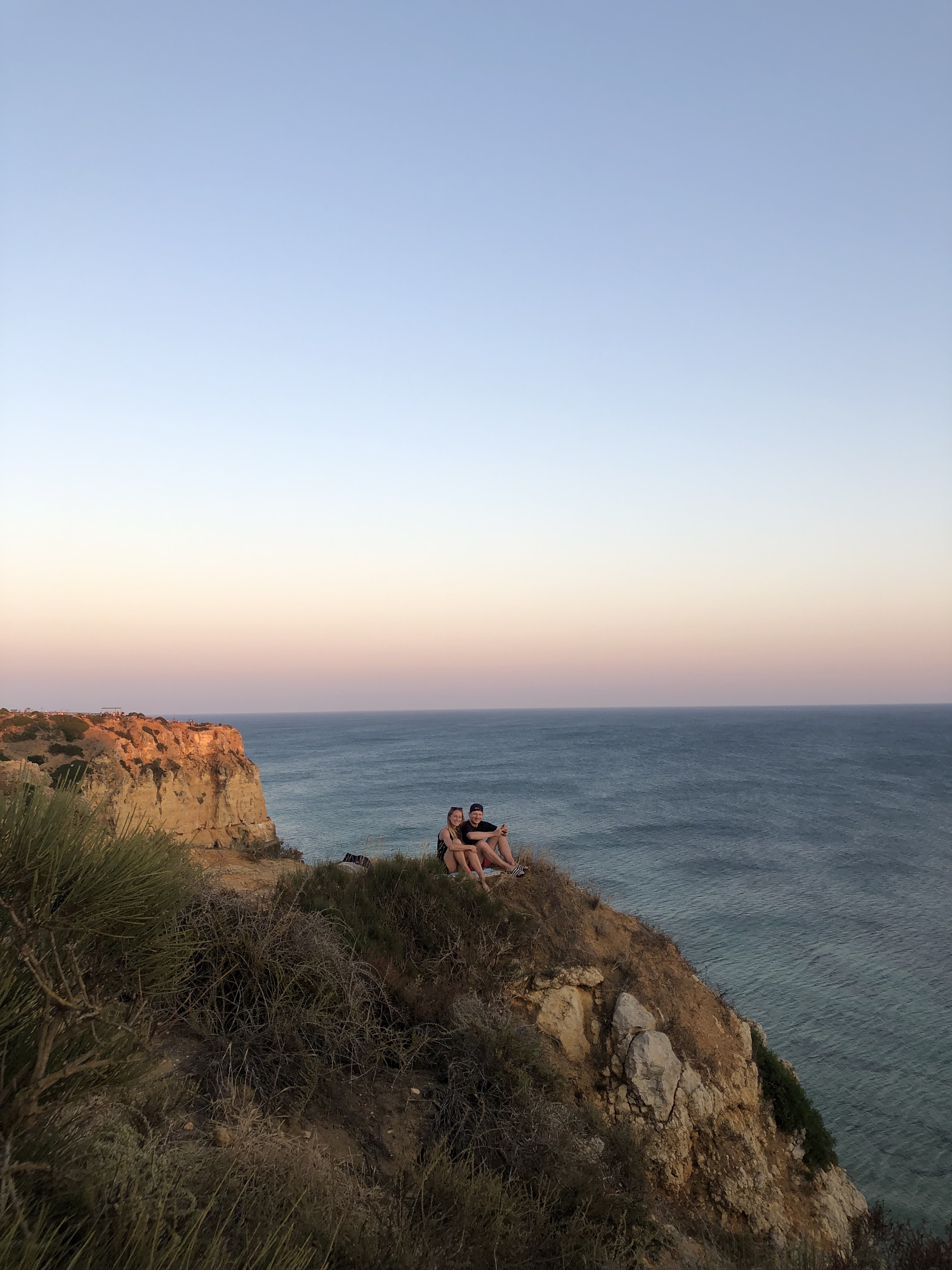 View of a pastel sunset over seaside cliffs on a clear evening