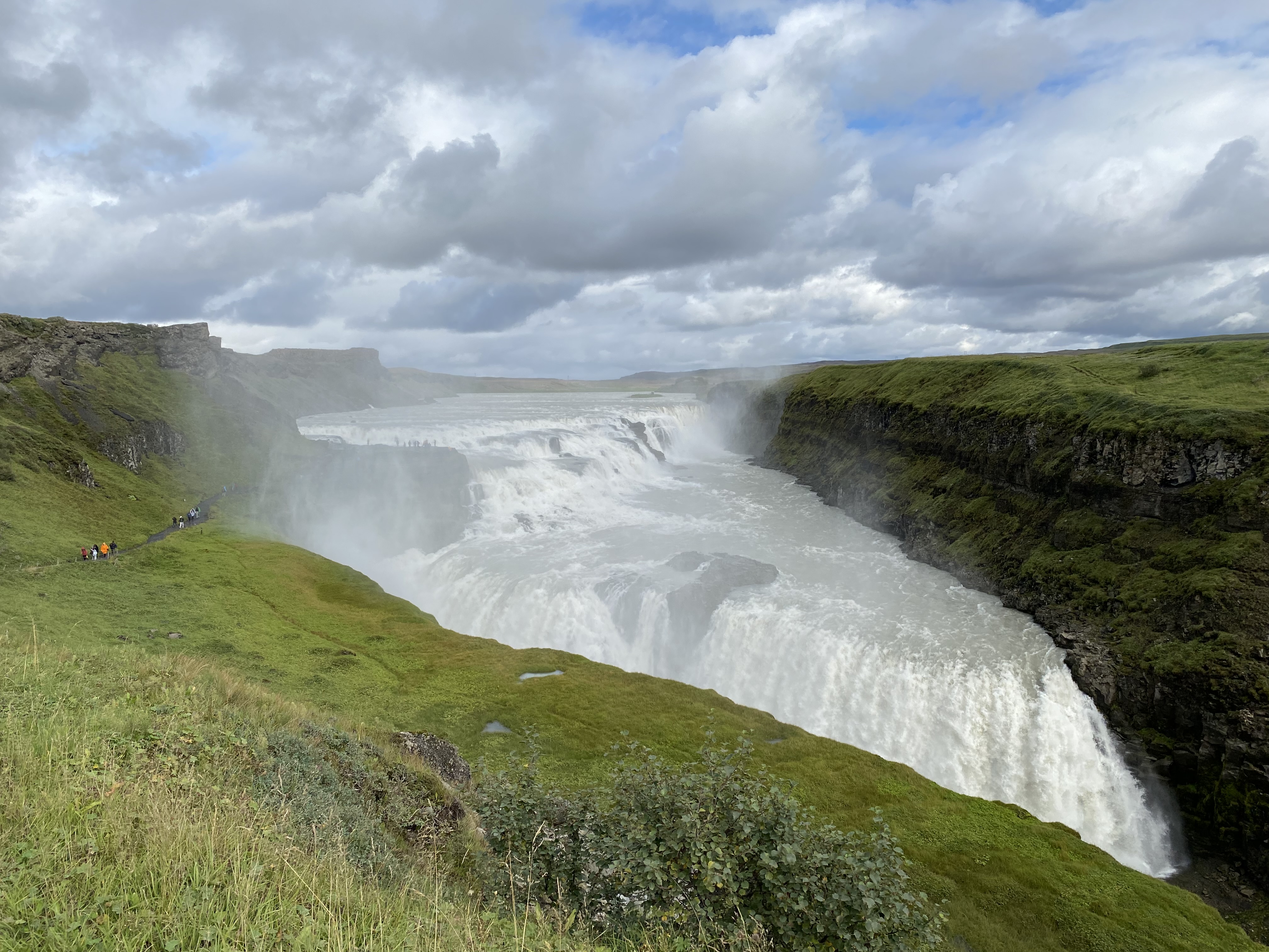 A view of a beautiful waterfall with a view of nature in the distance.
