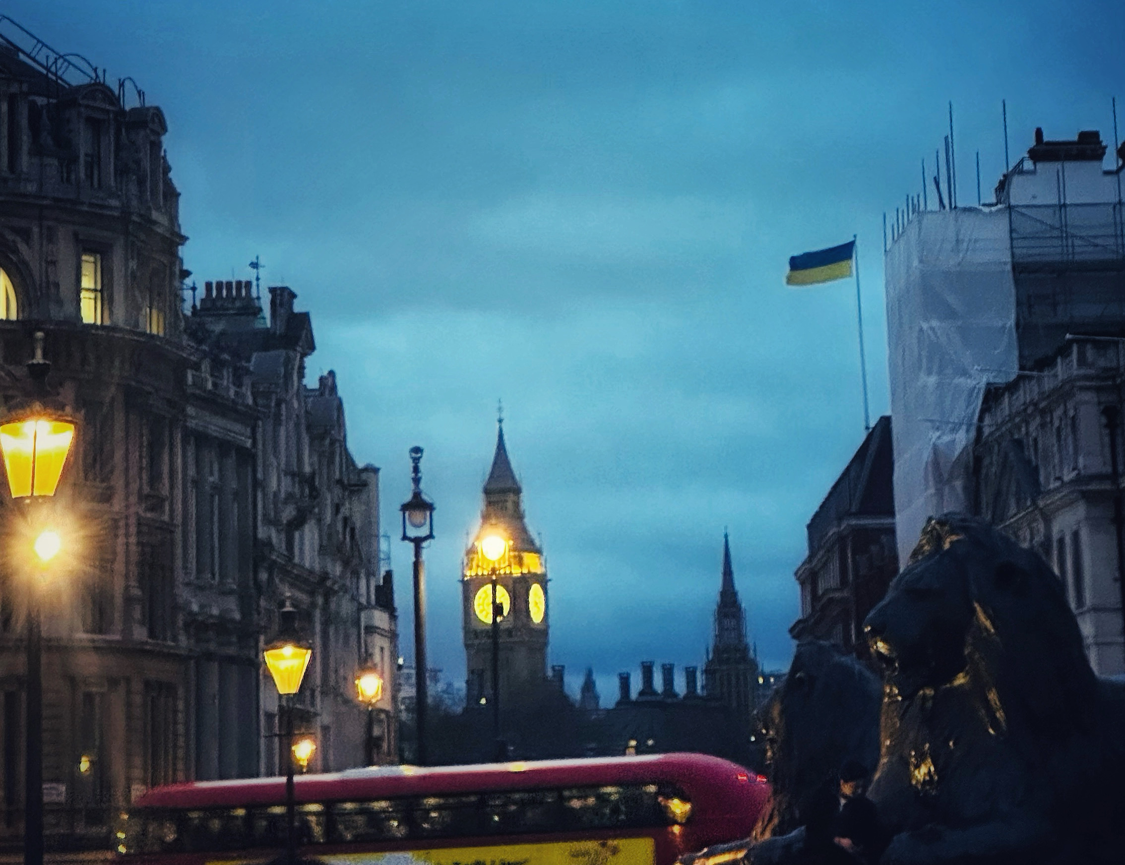 View of a foggy London street at dusk with Big Ben lit up in the distance