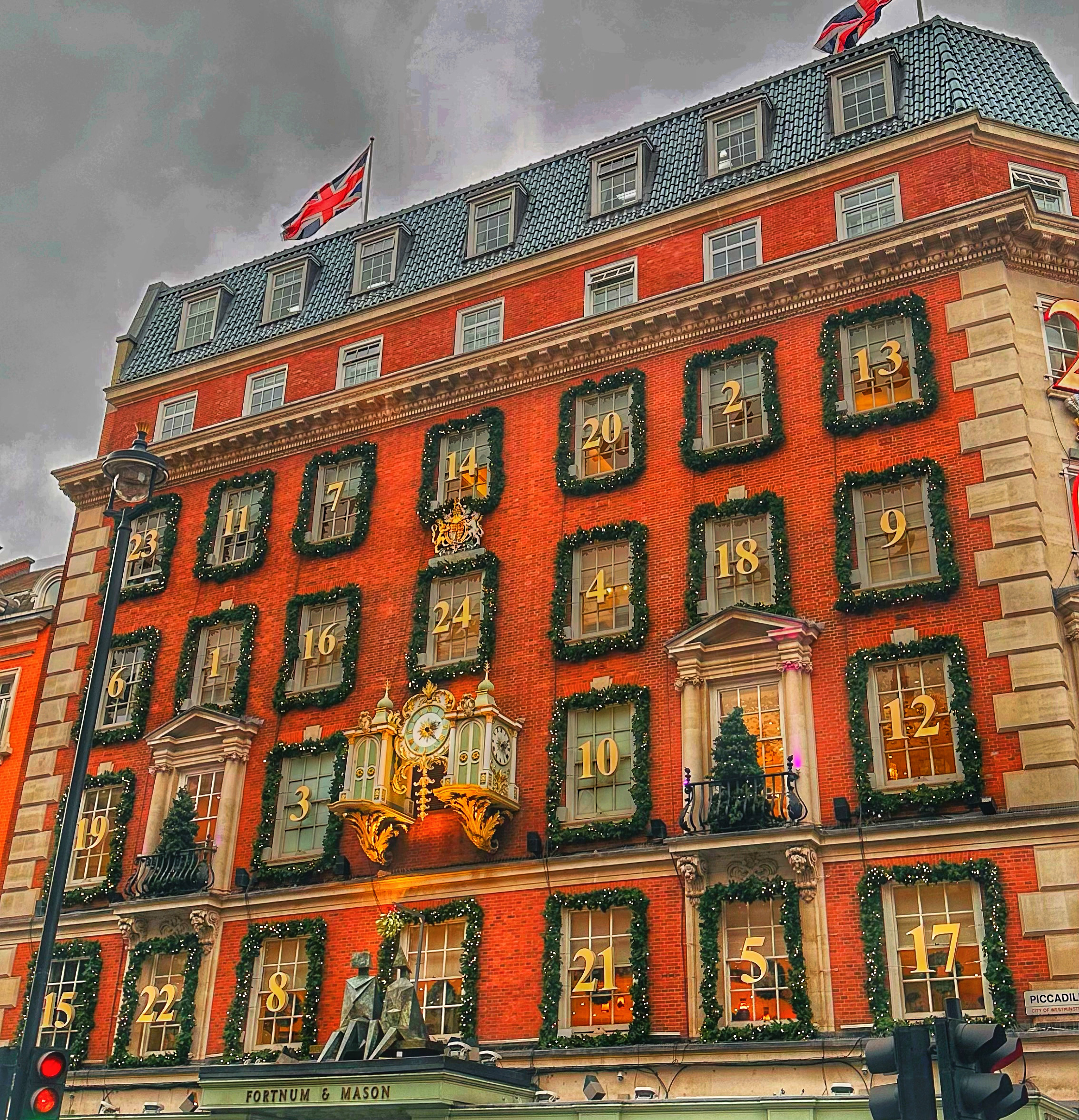 View of a hotel facade decorated with small Christmas trees and garlands on a cloudy day