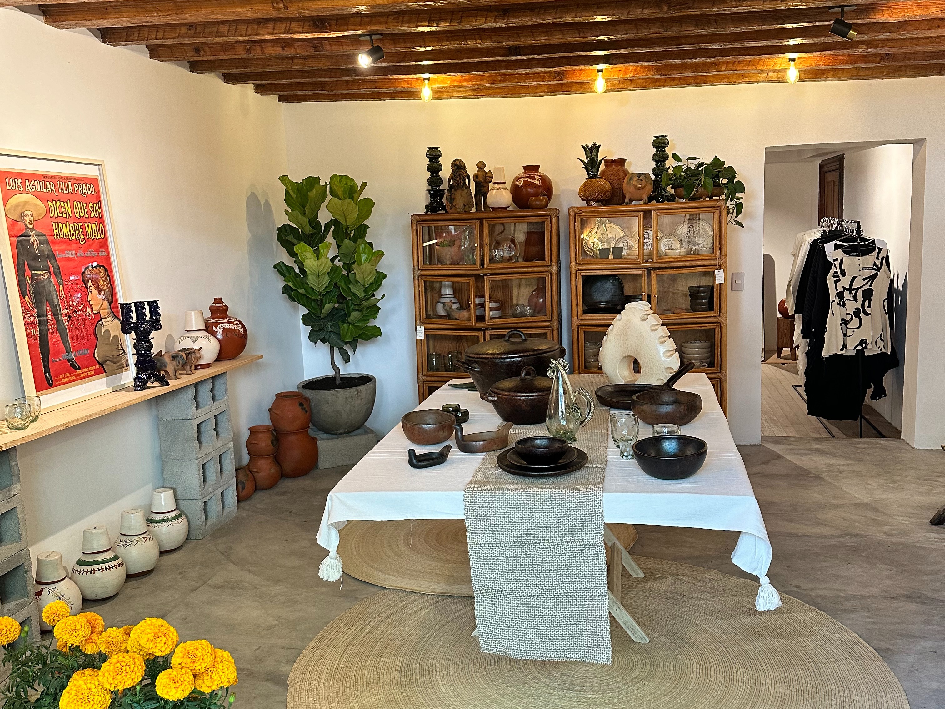 The interior of a retail store with various ceramics and pieces of clothing on display