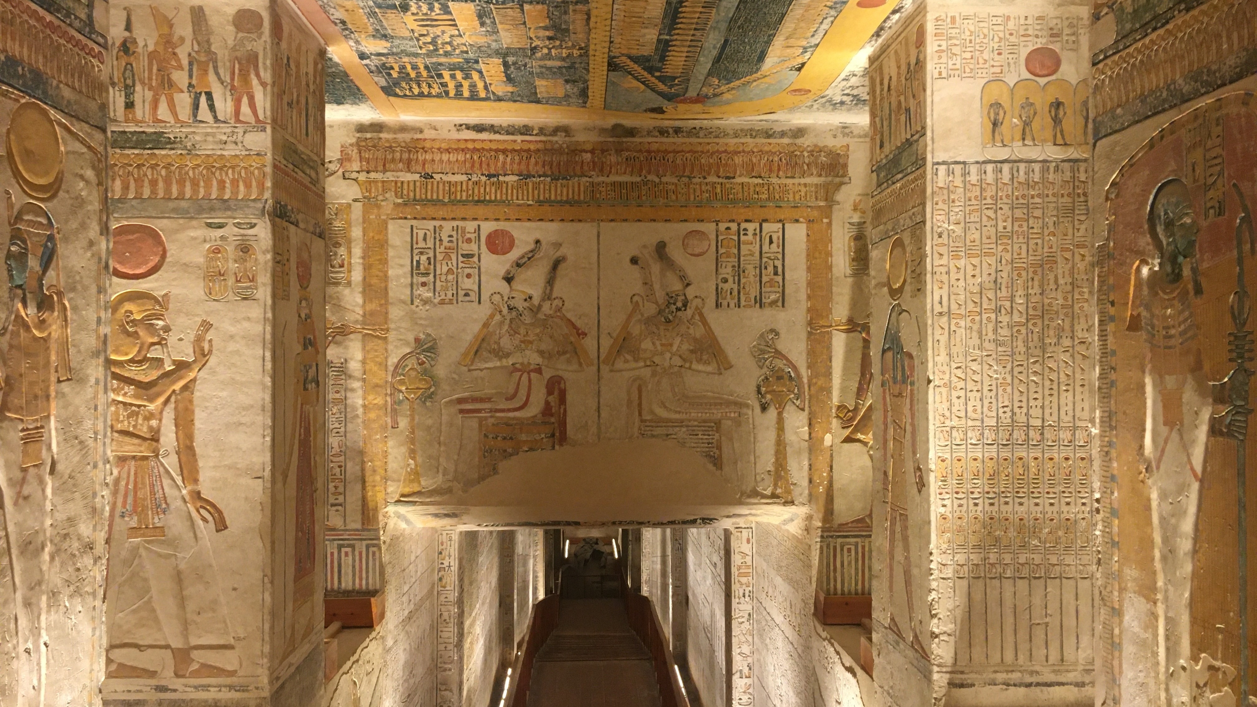 The intricately decorated interior of an ancient Egyptian tomb with hieroglyphics and wall carvings.