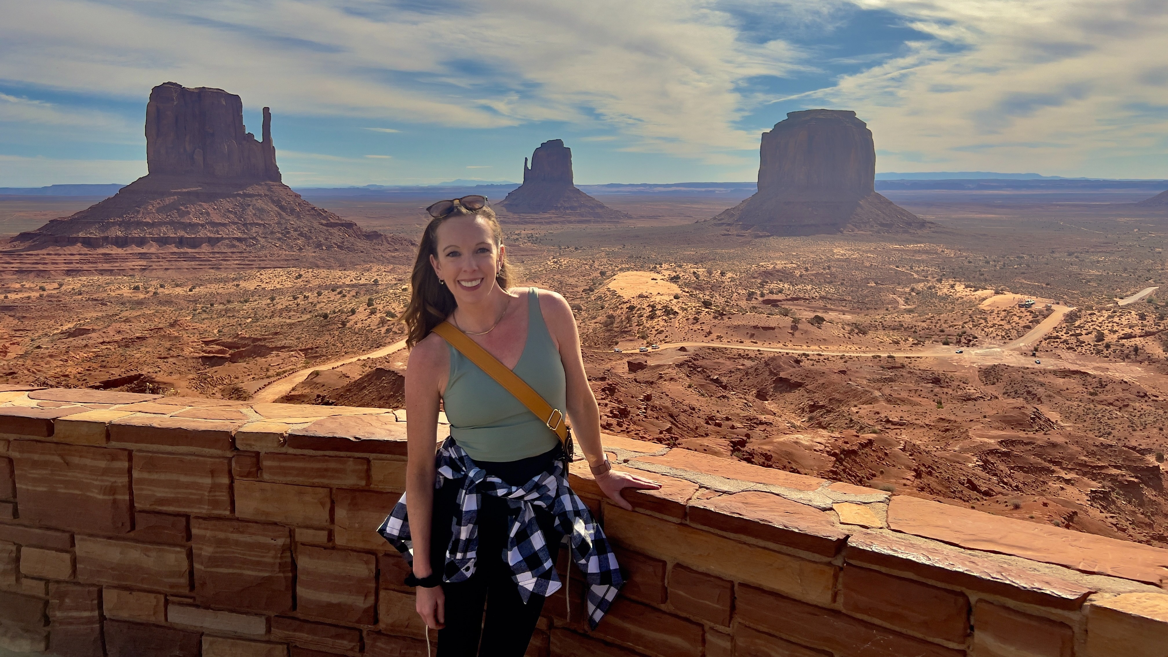 Advisor posing at an overlook with desert mesas in the background.