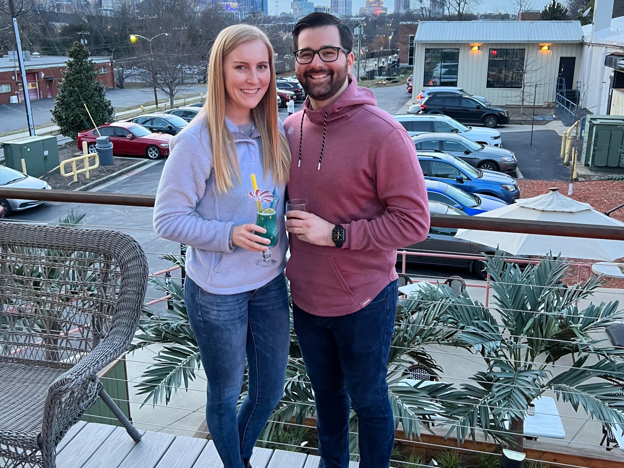 Couple with a drink standing on a terrace.
