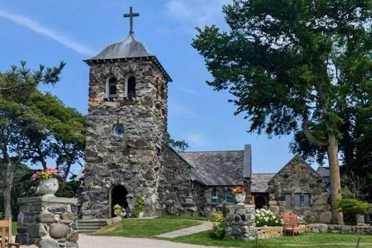 A church surrounded by a green lawn during the daytime