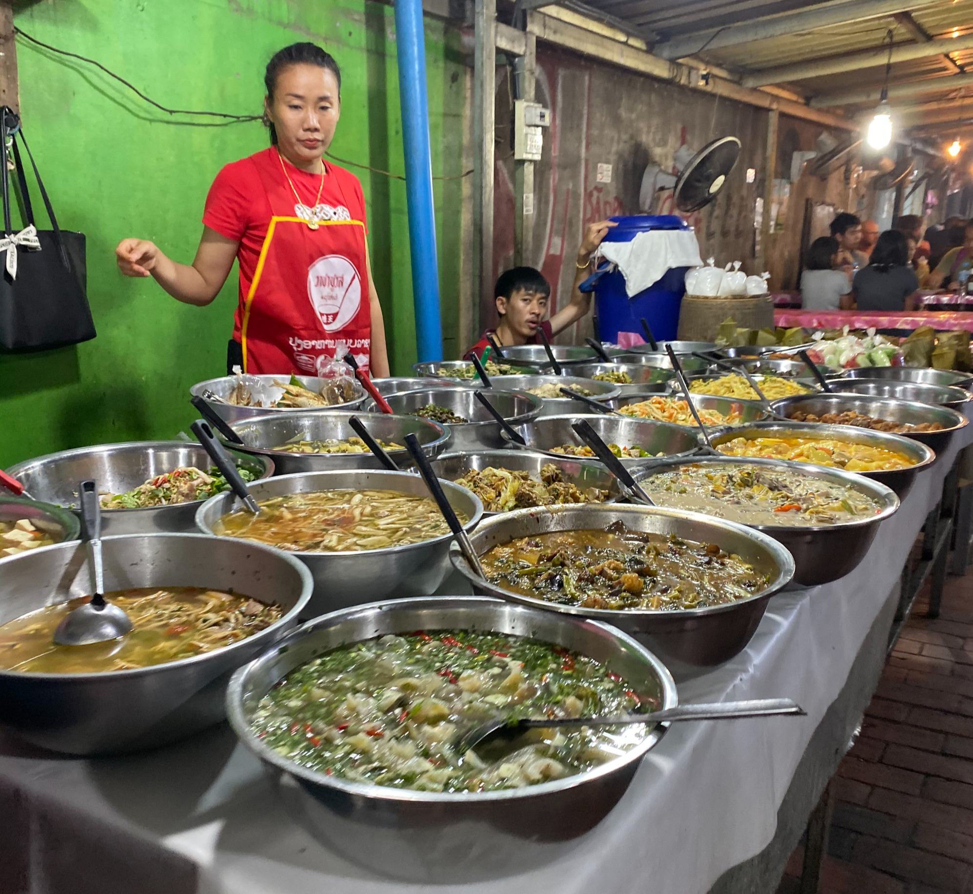 Numerous bowls of traditional food on a table in a food market