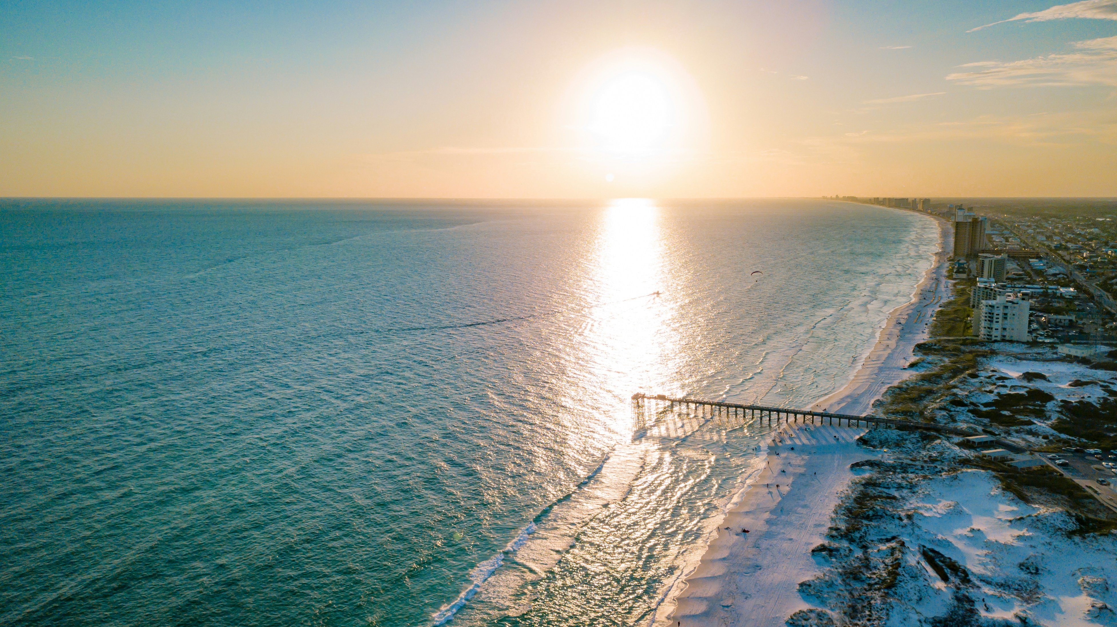 Aerial view of a beach coastline with buildings along the road