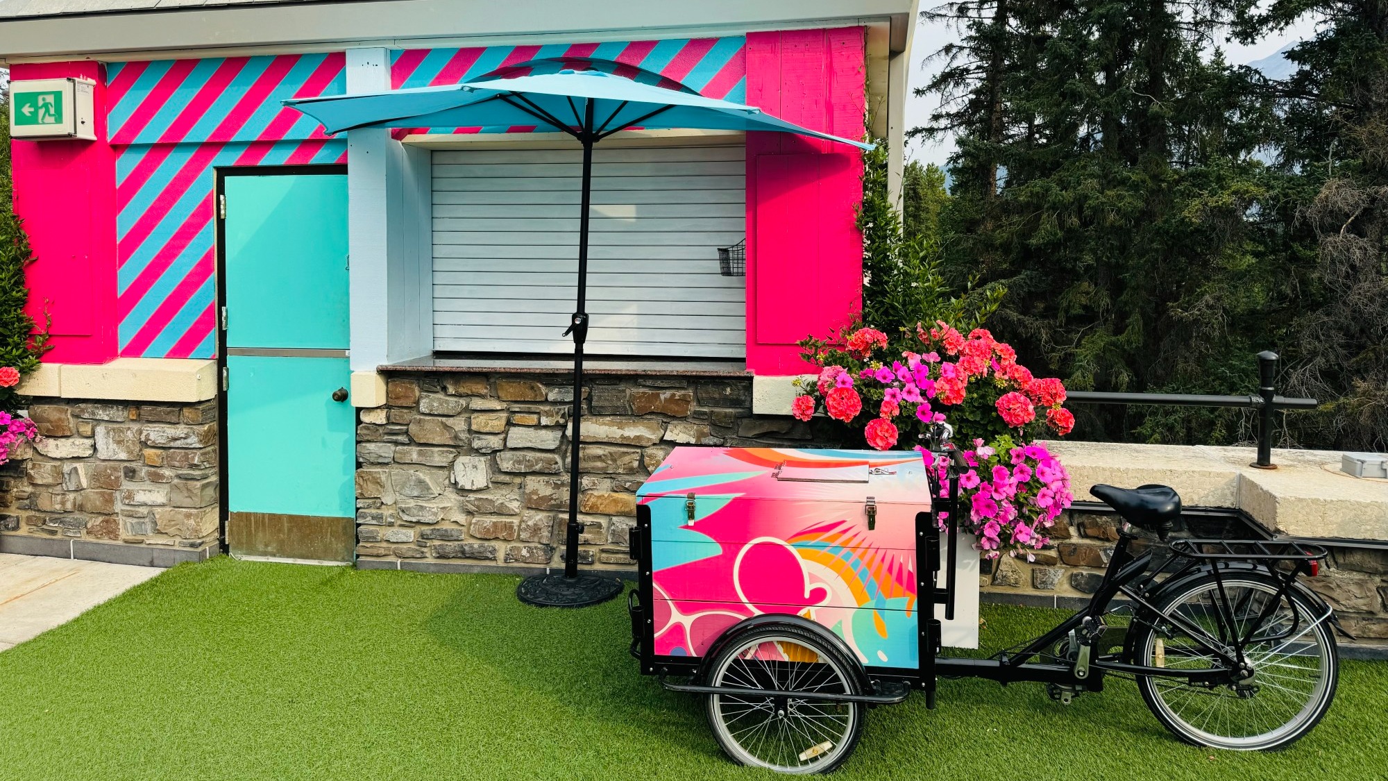 A bike in front of a pink and blue cabin.