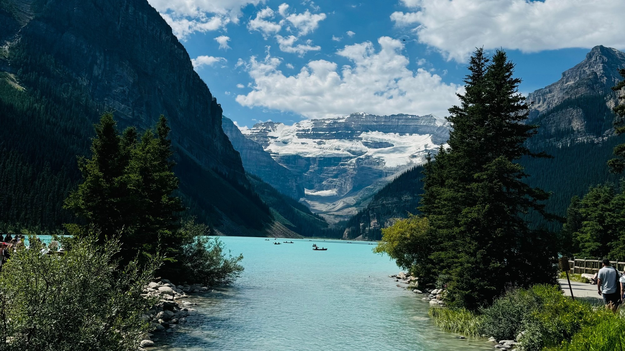 A bright blue lake between snow-capped mountains.
