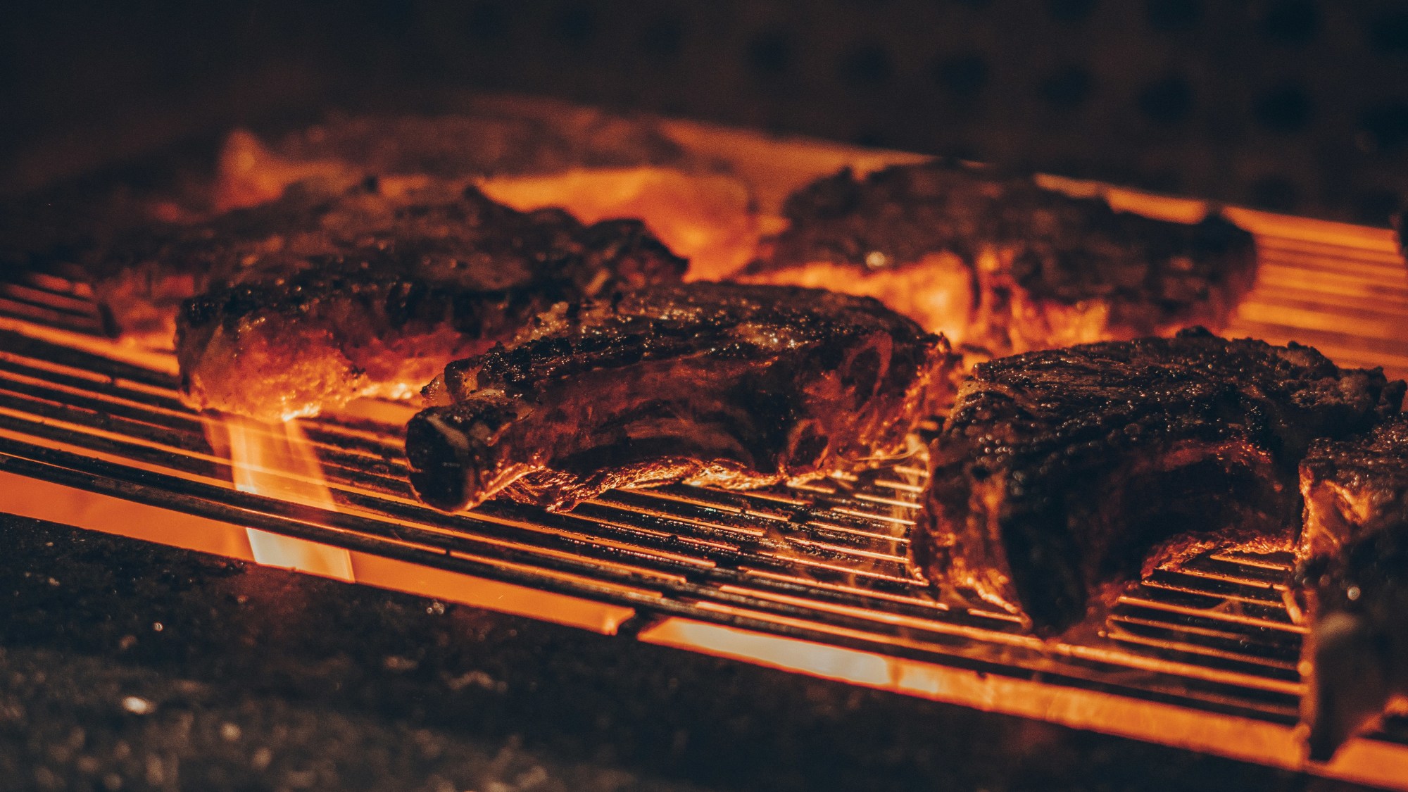 Meat on a red hot grill.