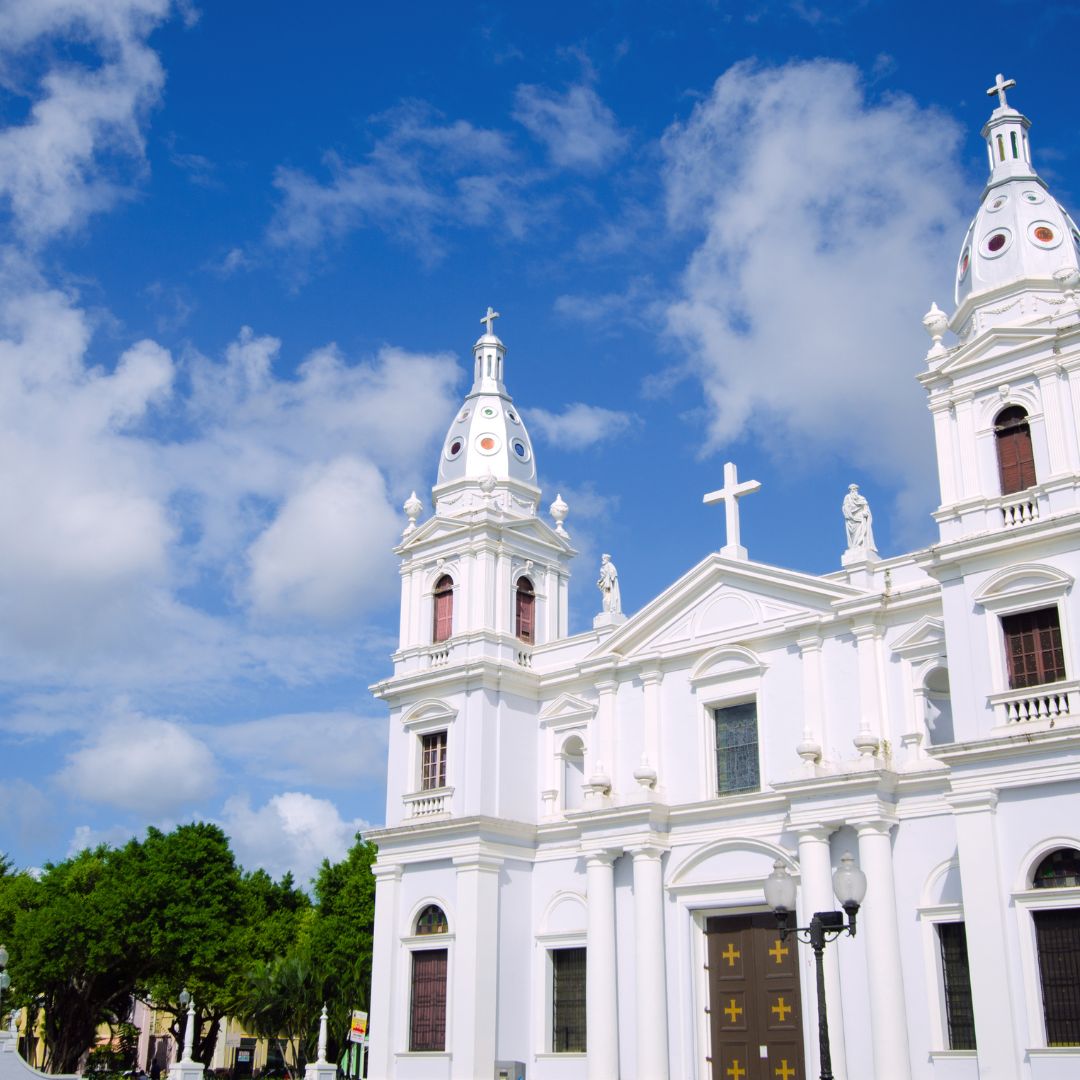 A white church reaches for the clear blue sky on a clear day.