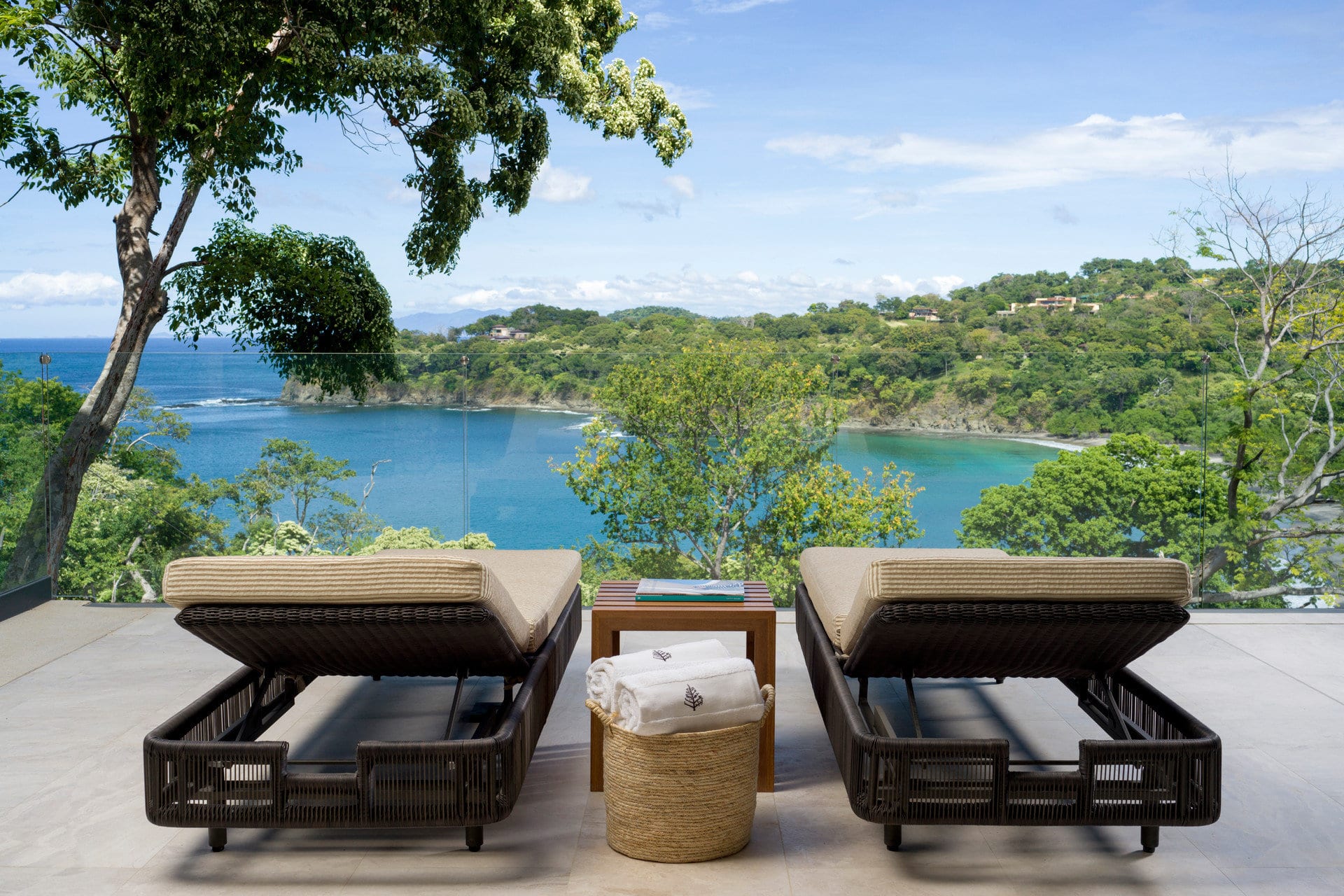 Twin luxe loungers sit on a terrace overlooking a beach somewhere near the tip of the Papagayo Peninsula in Costa Rica